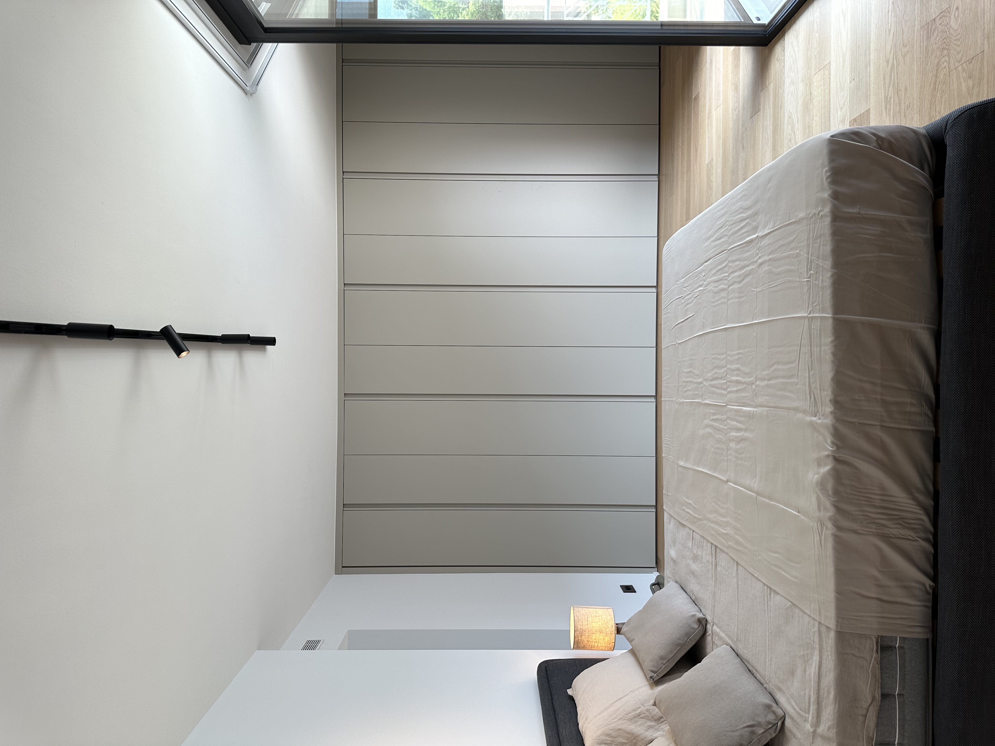 Modernes Schlafzimmer mit Einbauschrank und großem Fenster