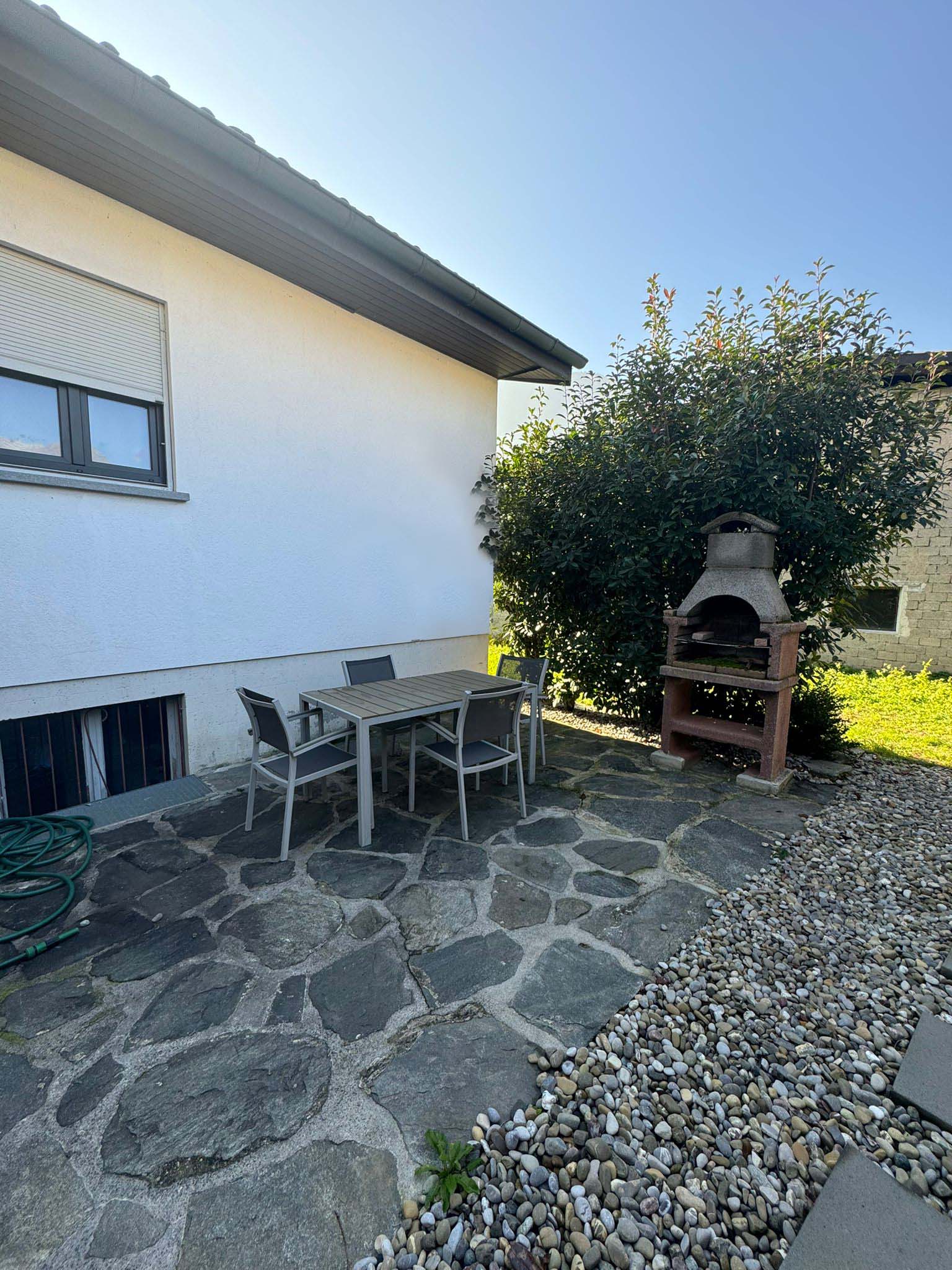 Terrasse mit Außenkamin und Gartenmöbeln