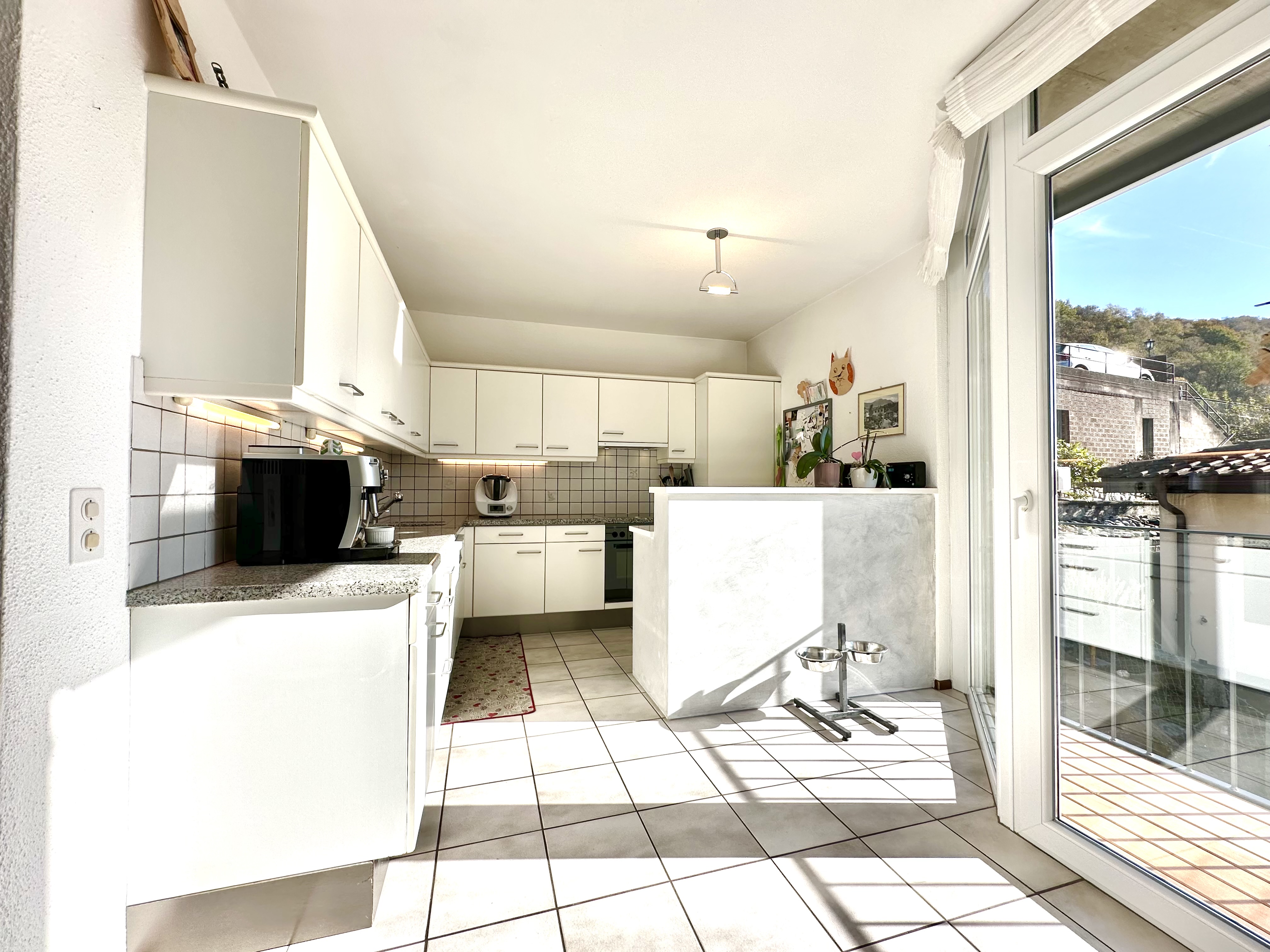 Helle, moderne Küche mit Balkonfenster