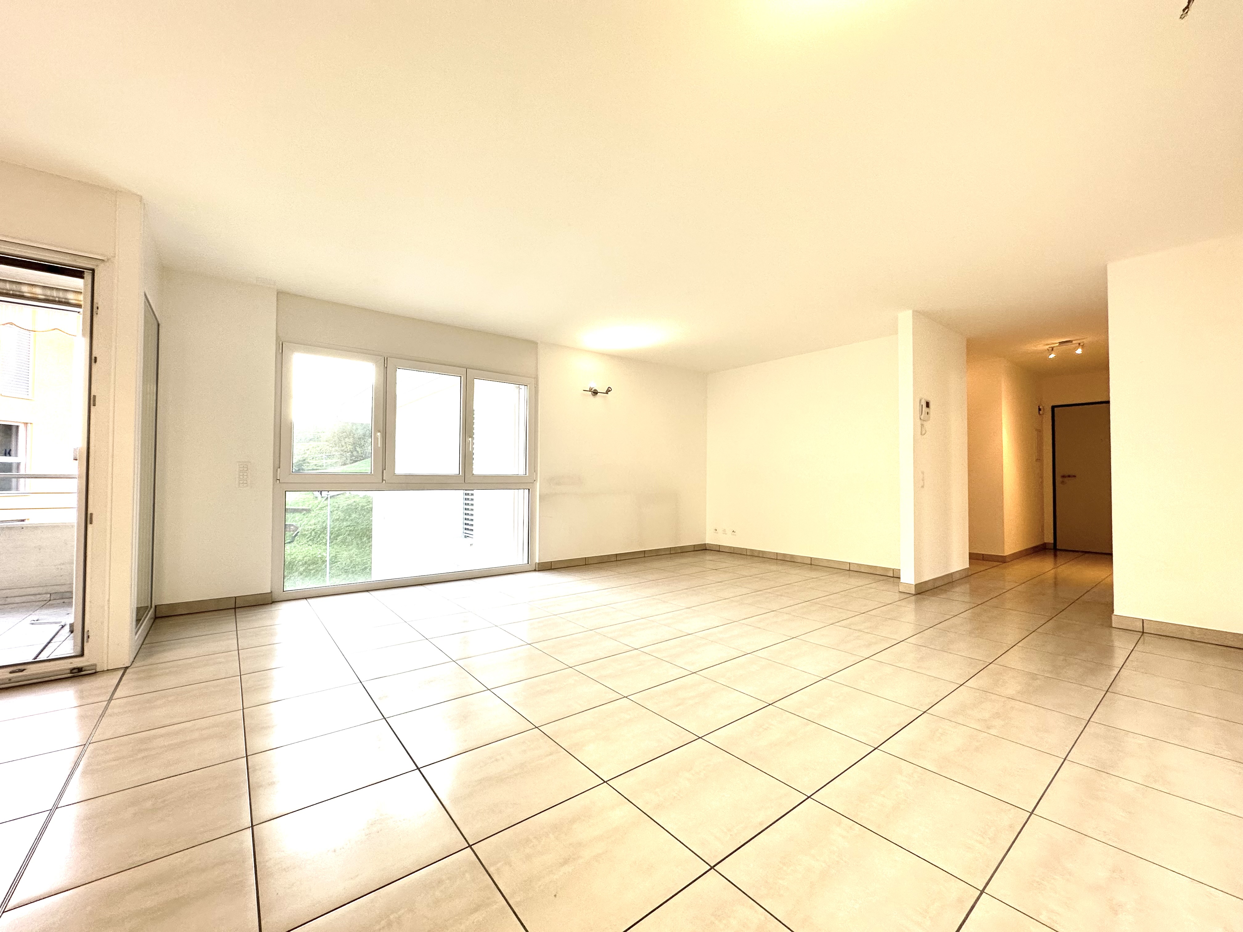 Leeres, helles Wohnzimmer mit Fliesenboden