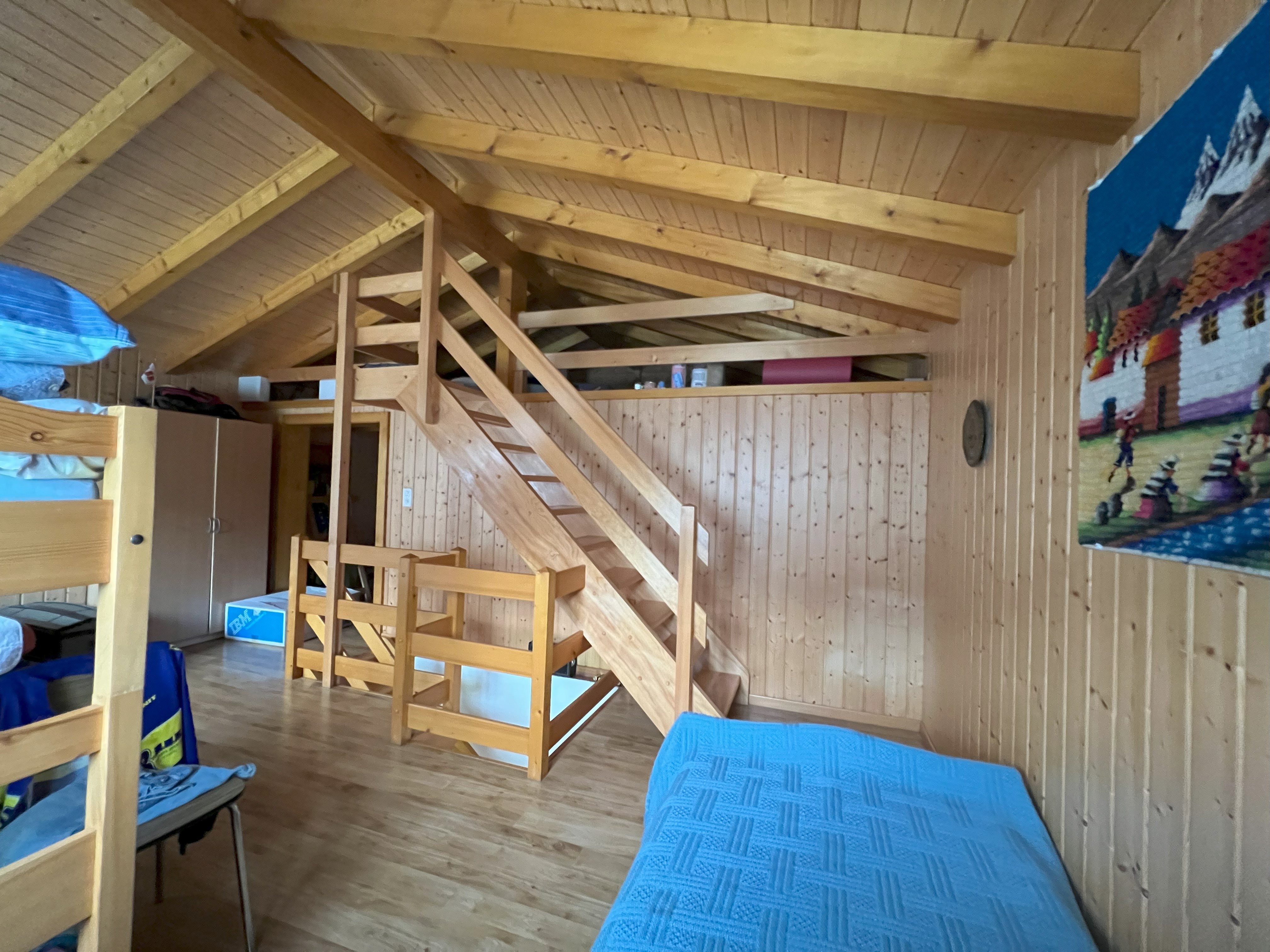 Holzverkleidetes Dachgeschosszimmer mit Schlafebene