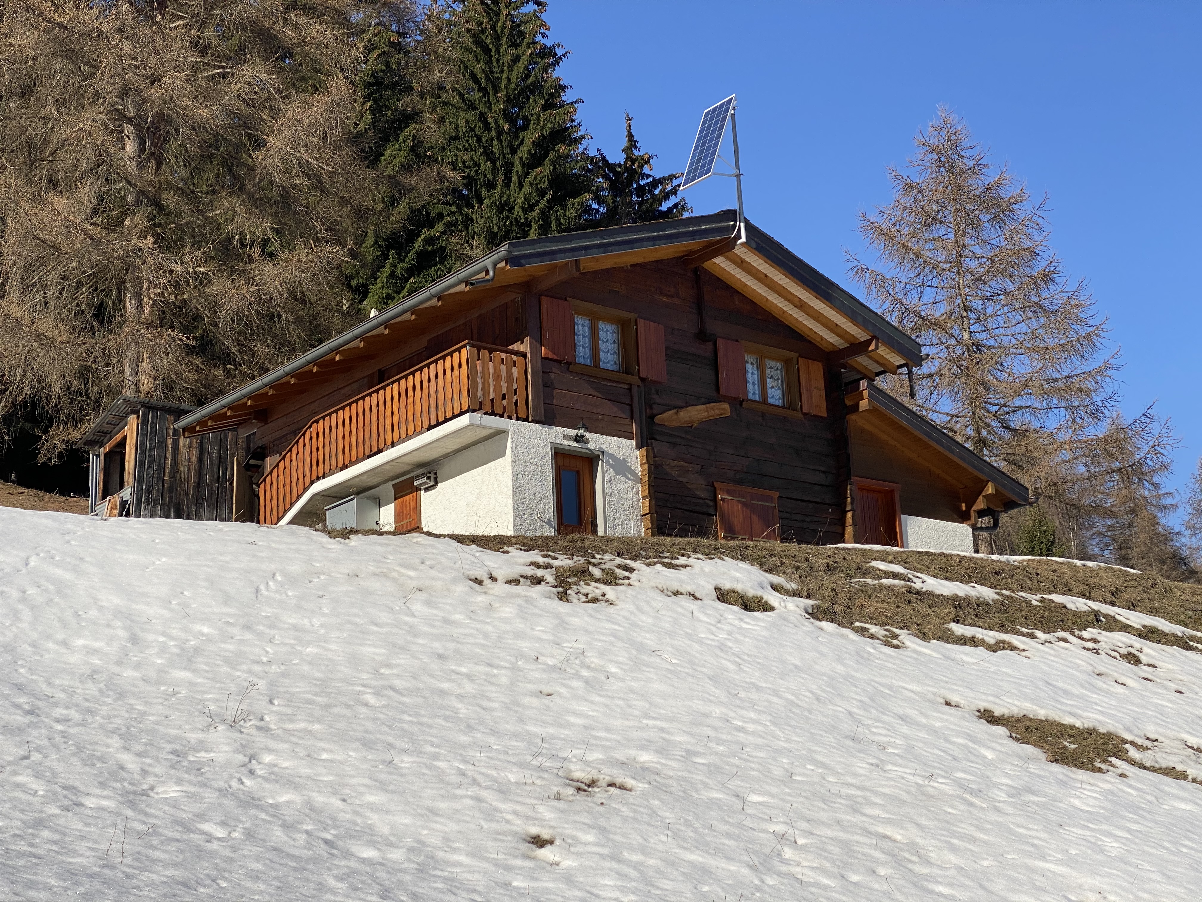 Berghaus mit Solarpanel im Schnee