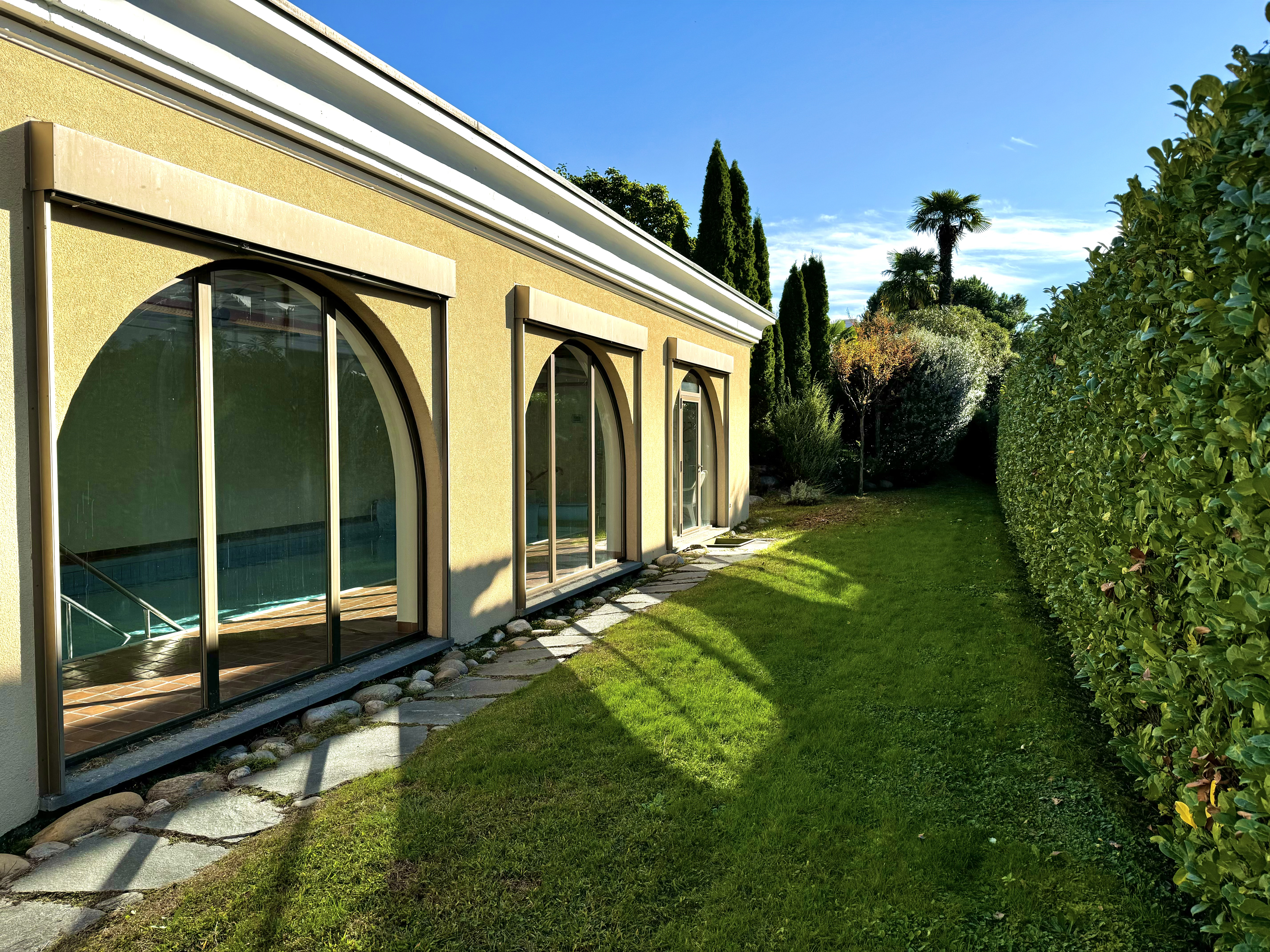 Exterieur mit Garten und großen Rundbogenfenstern