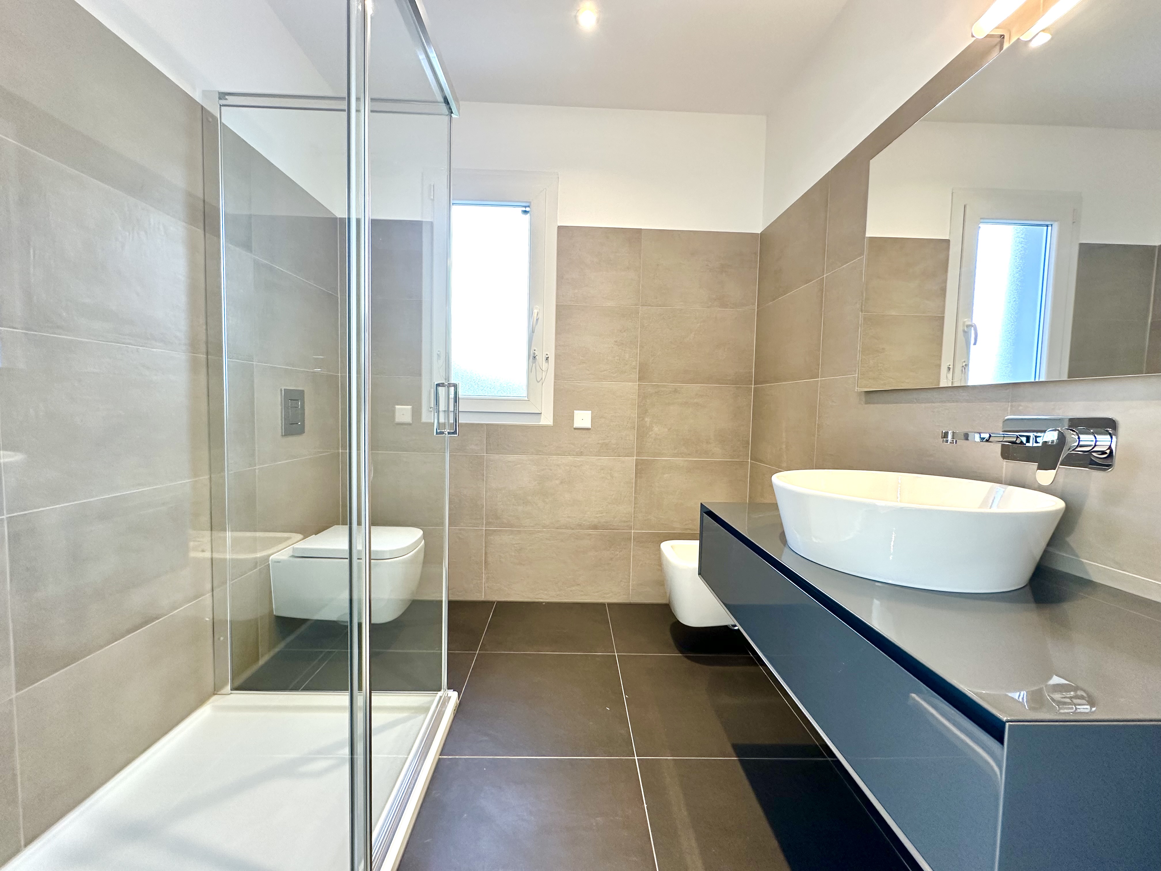Modernes Badezimmer mit Glasdusche und Aufsatzwaschbecken