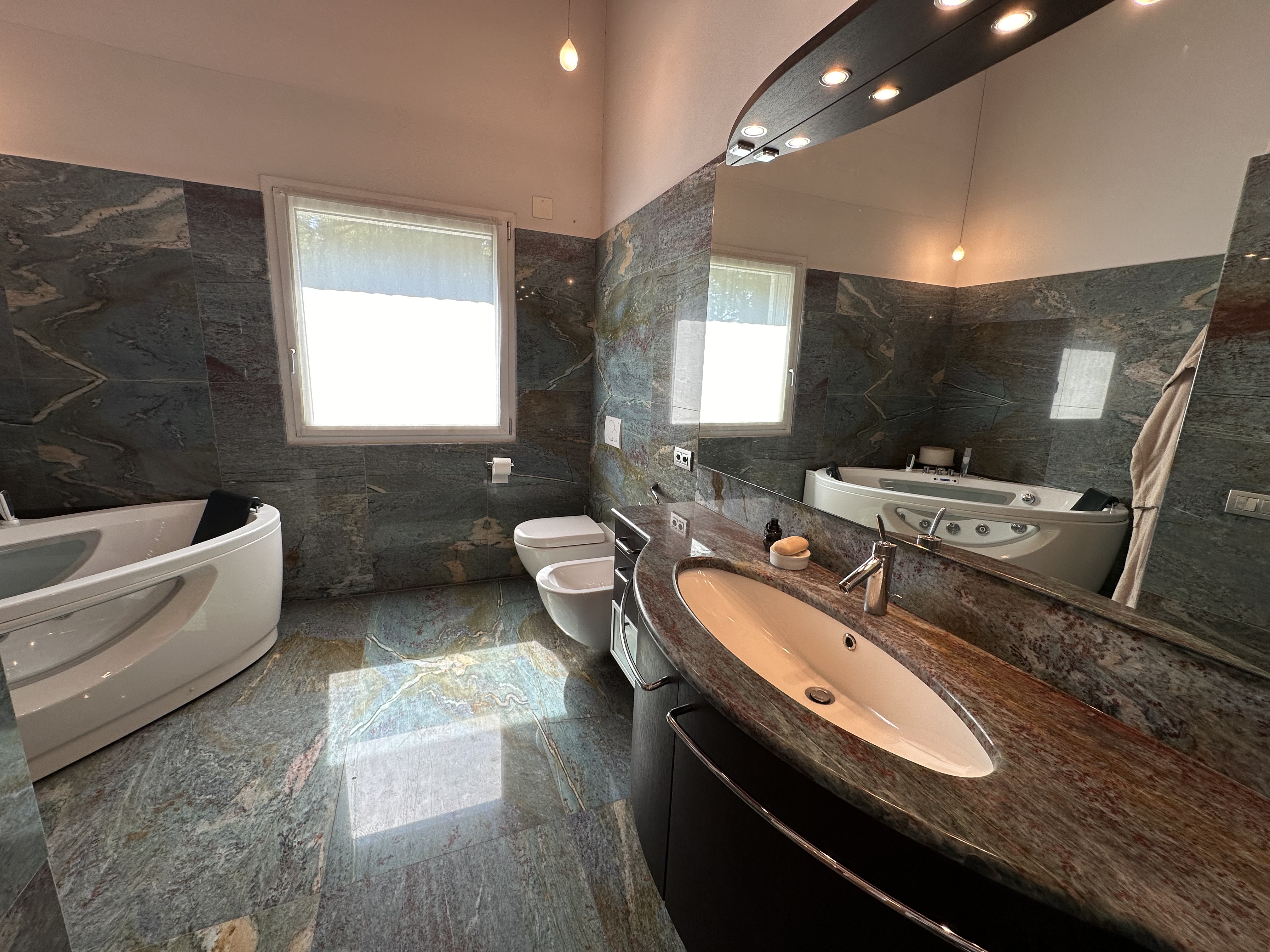 Luxuriöses Badezimmer mit Natursteinflächen