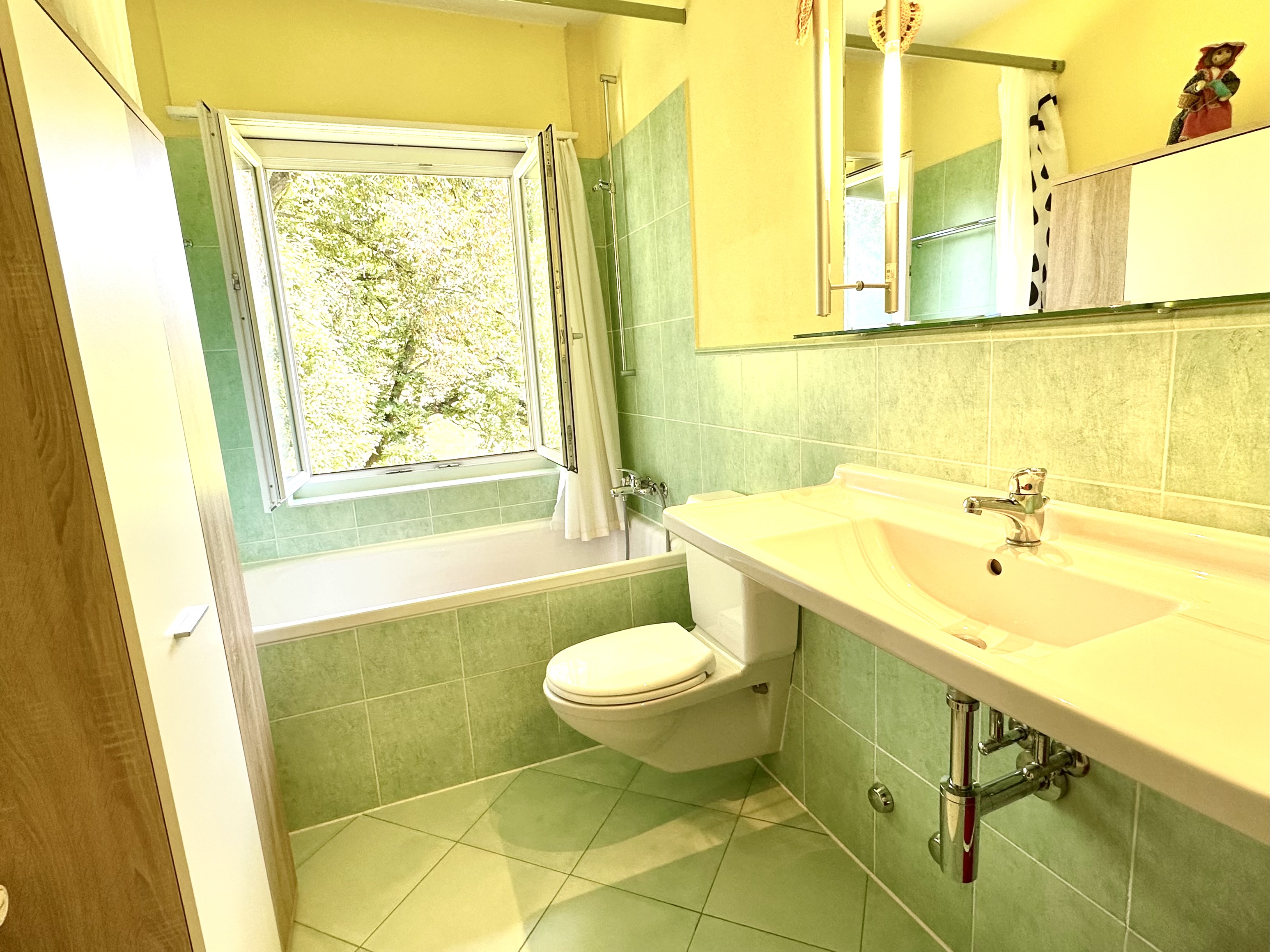 Helles Badezimmer mit Fenster und Wand-WC