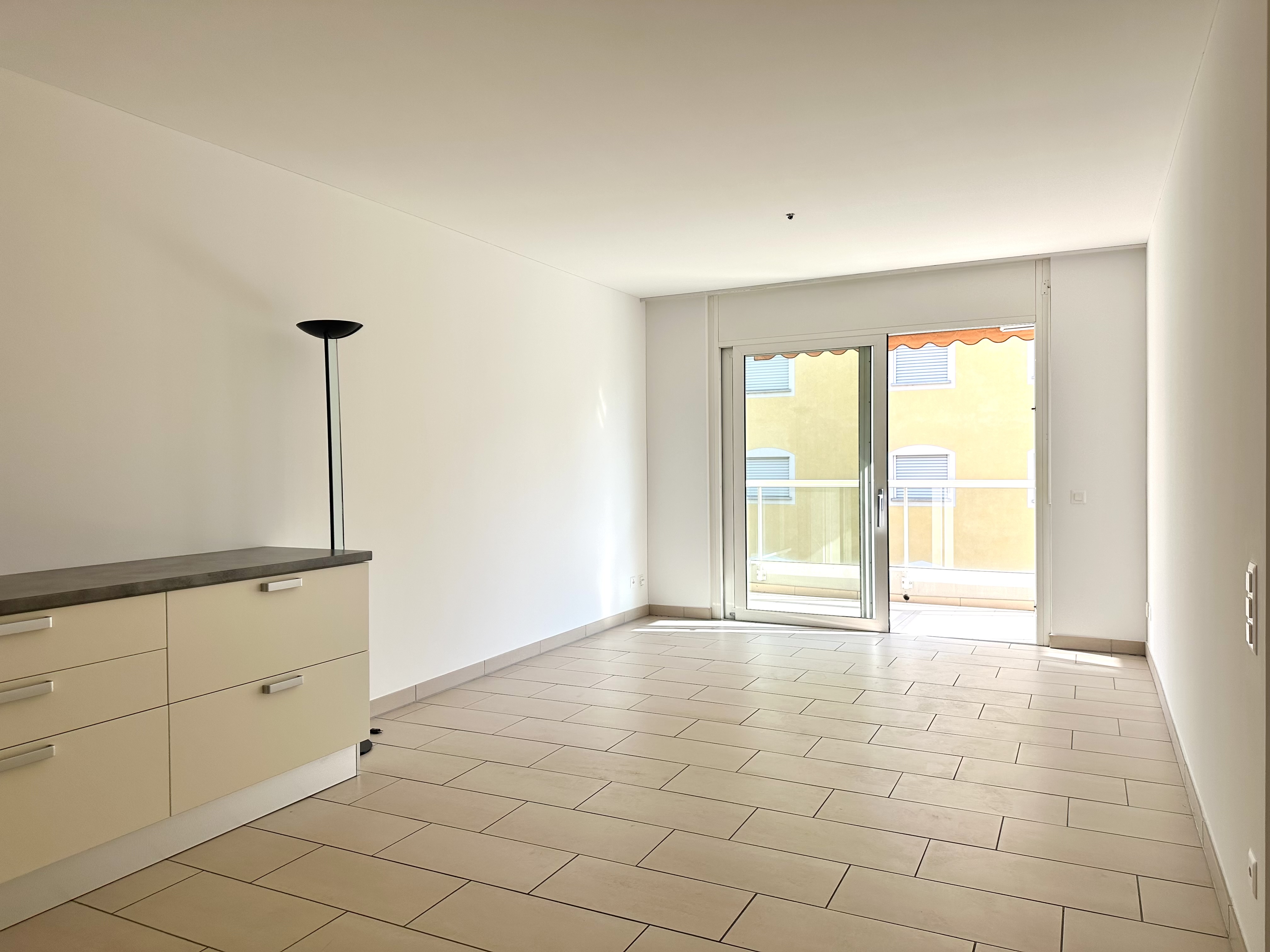 Leerer Wohnraum mit Balkonzugang