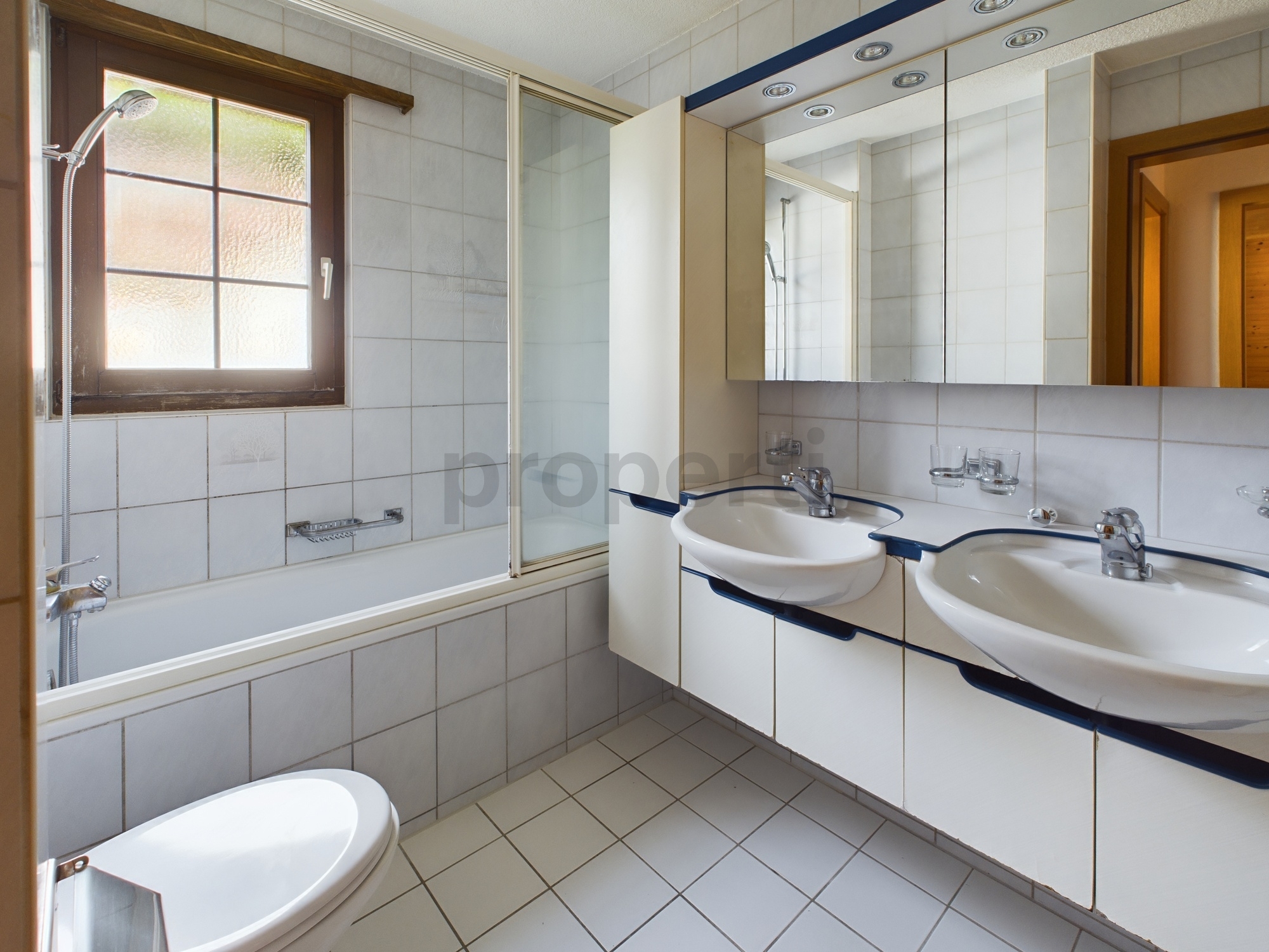 Badezimmer mit Doppelwaschbecken und Badewanne