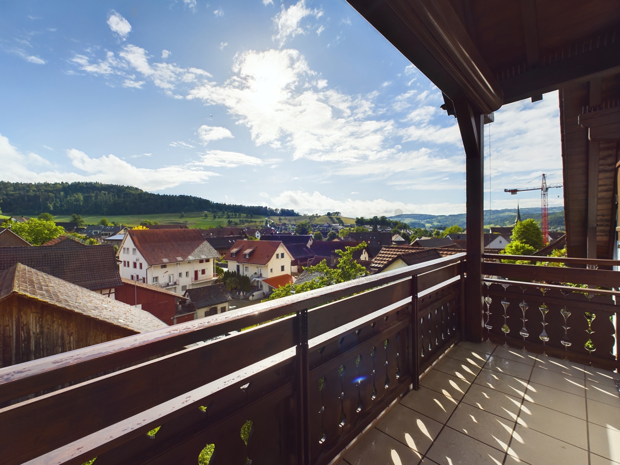 Balkon mit weitem Ausblick über ein Dorf und Hügel