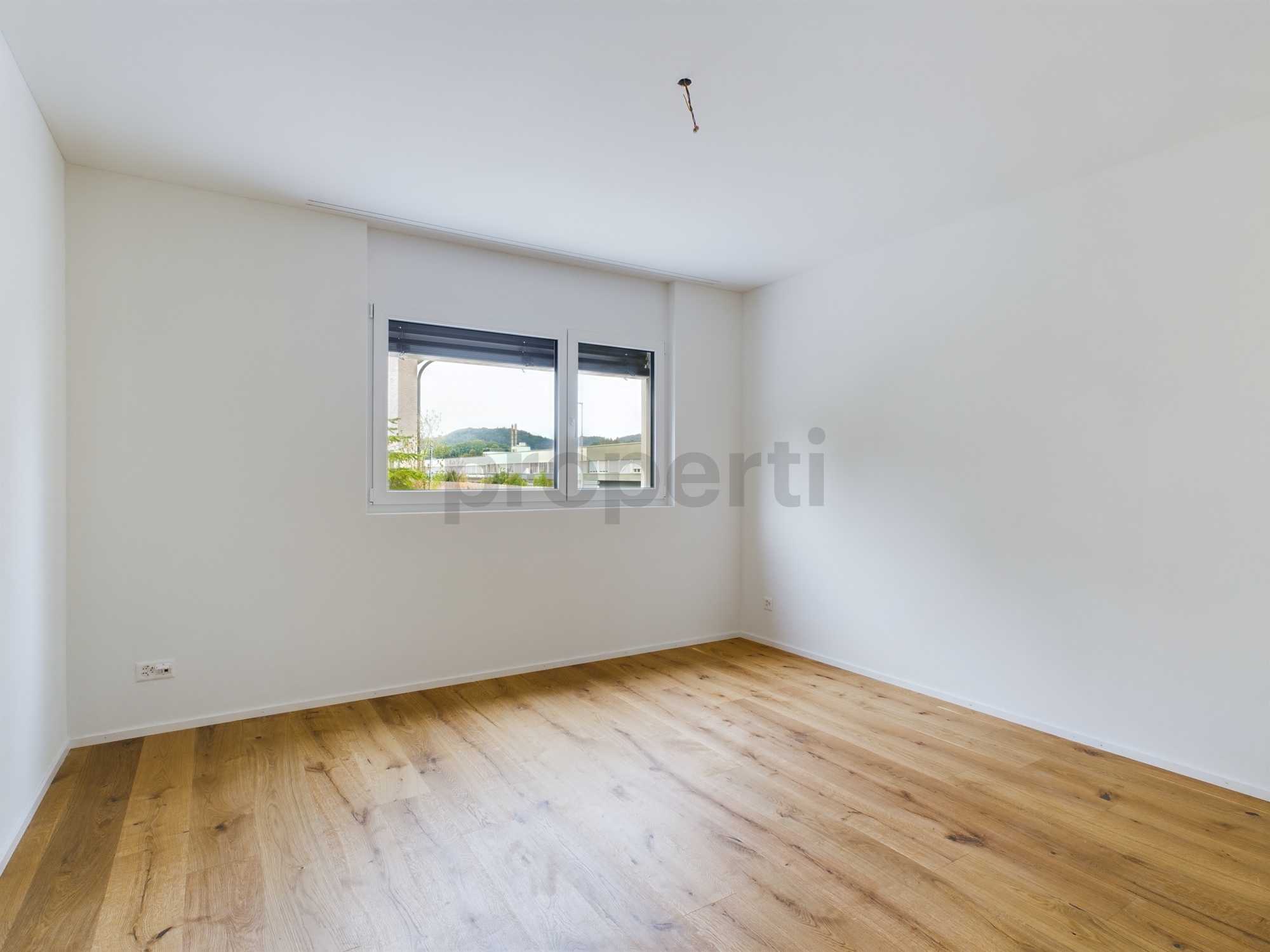 Leeres Schlafzimmer mit Parkett und Fenster