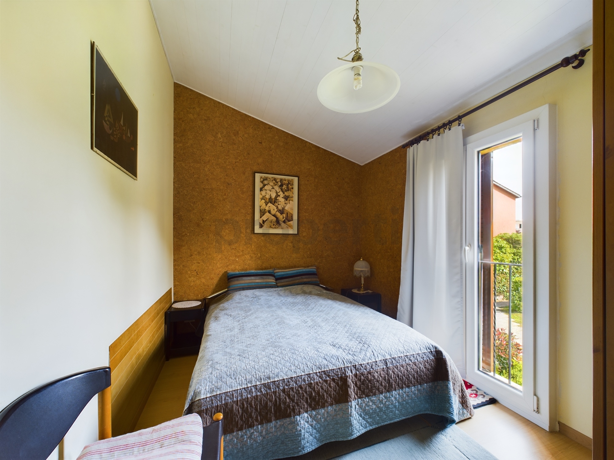 Helles Schlafzimmer mit Einzelbett und Balkontür