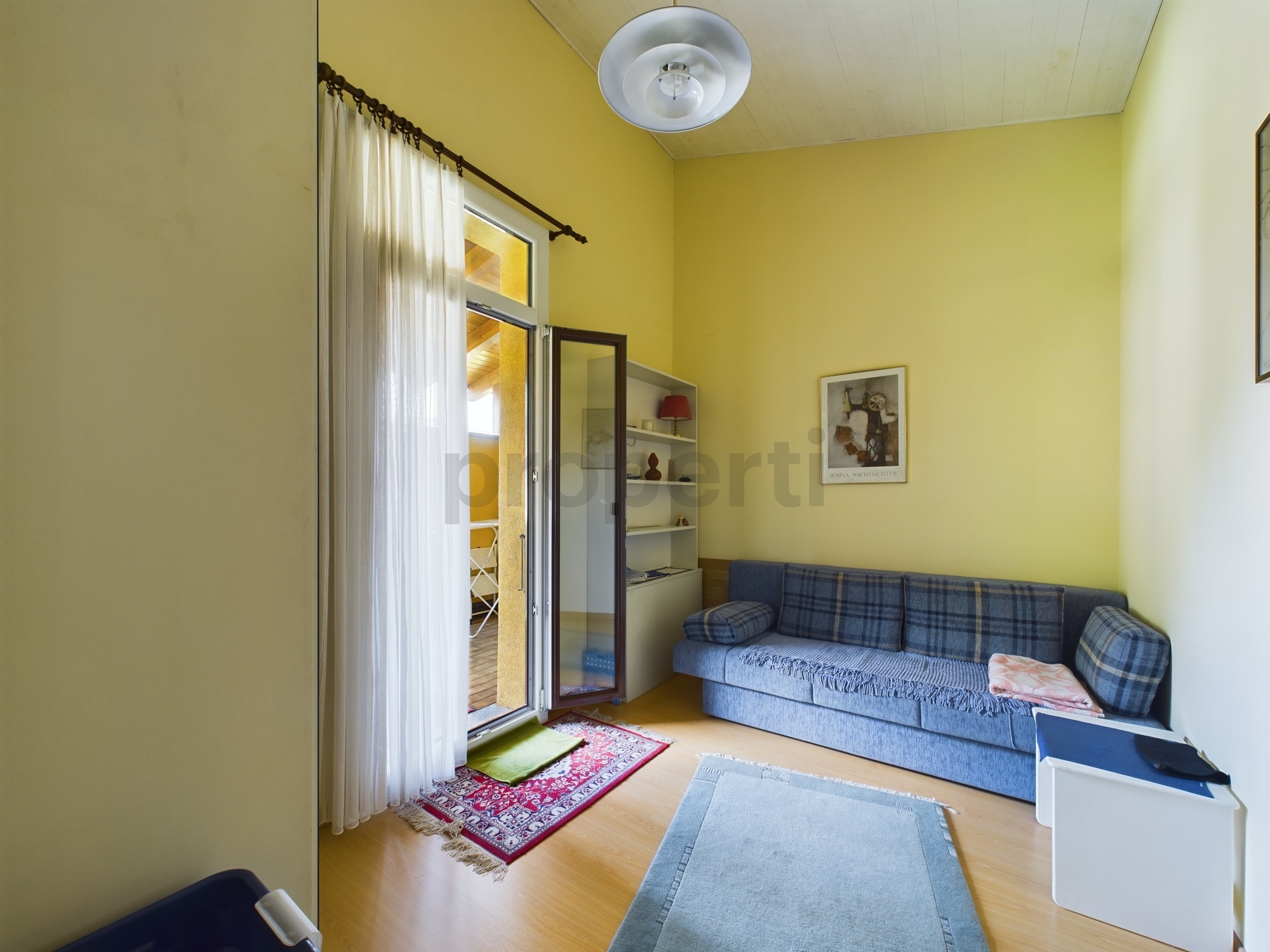 Helles Wohnzimmer mit Sofa und Balkonzugang