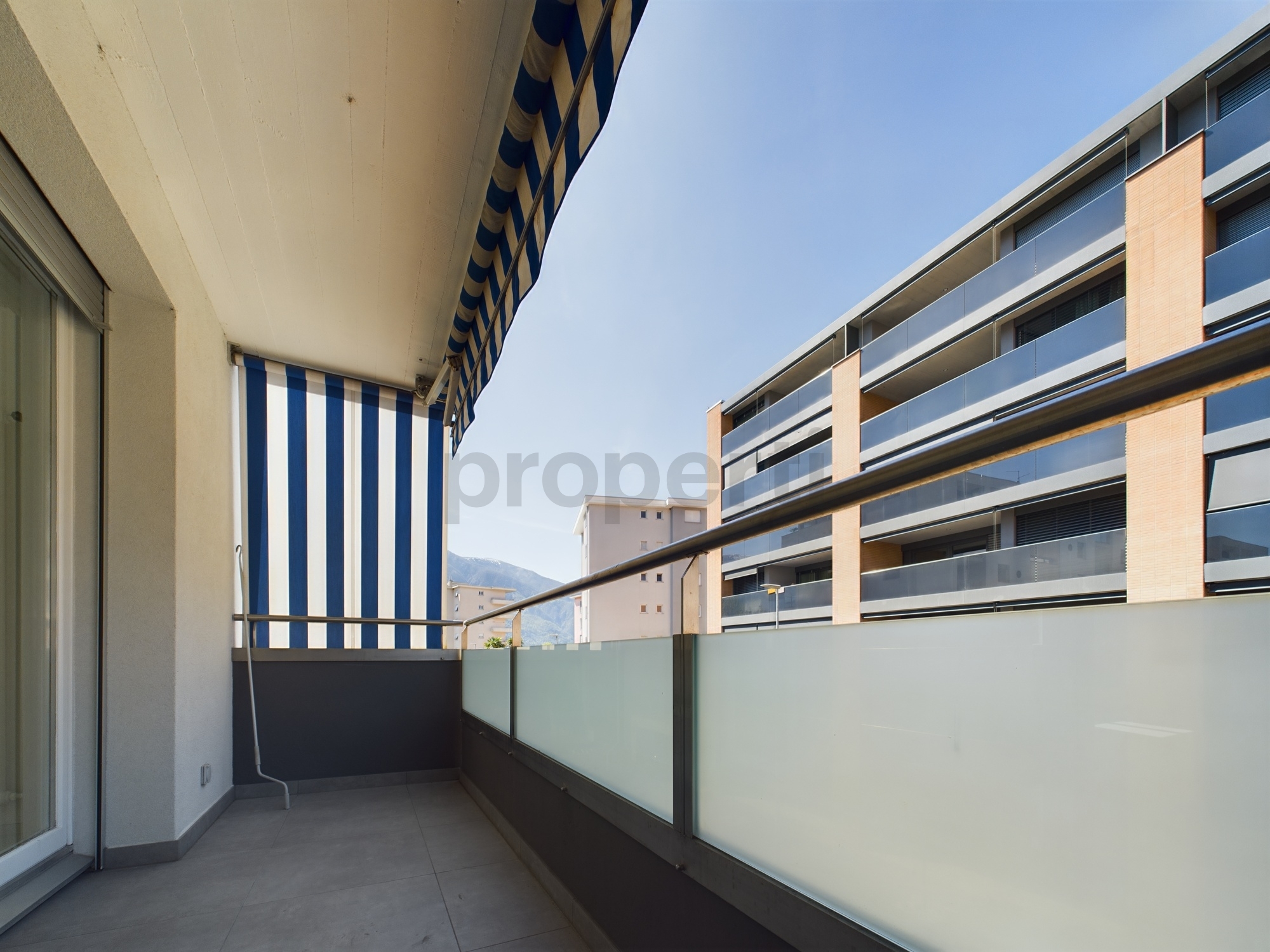 Balkon mit Markise und Glasgeländer