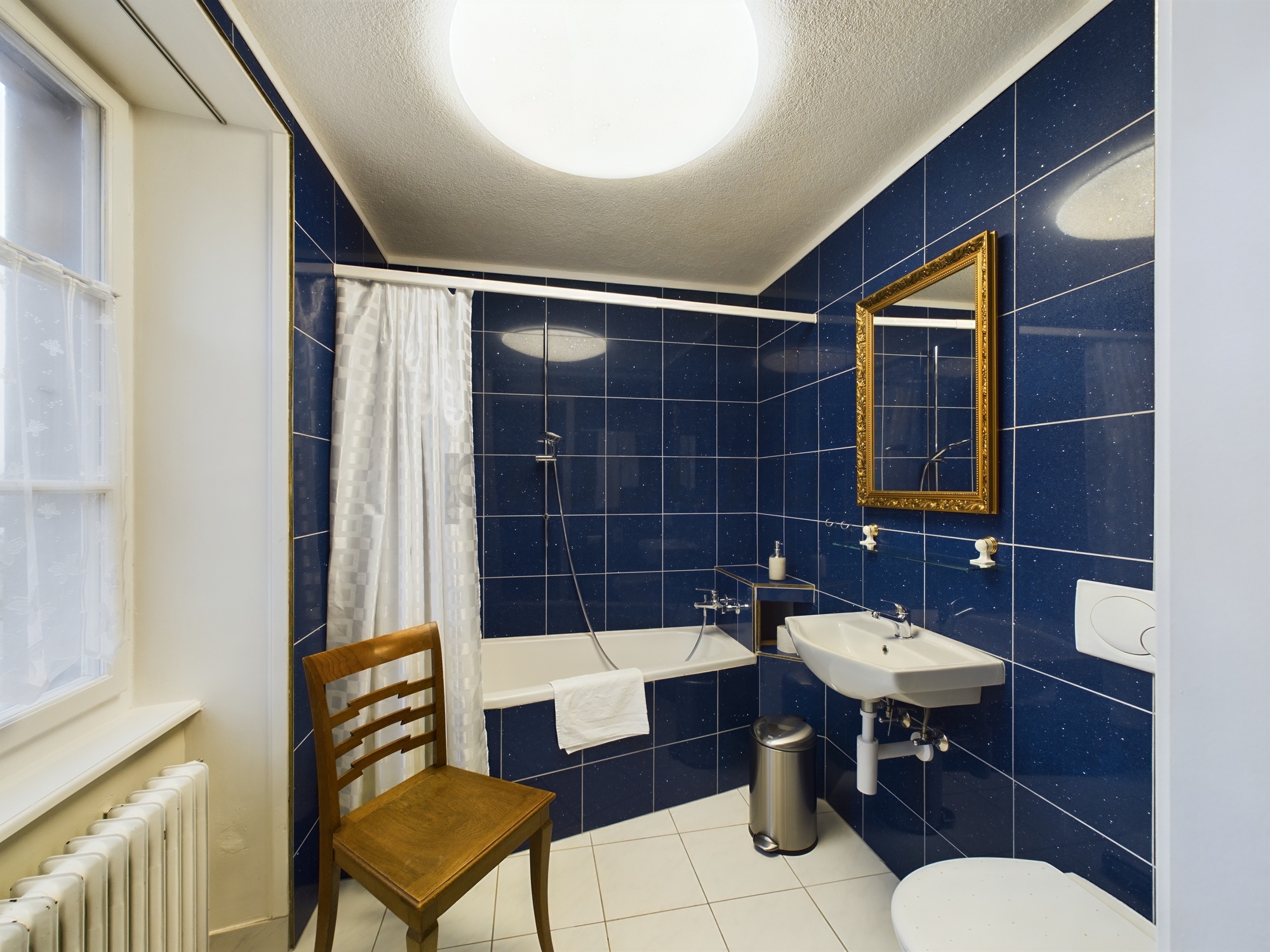 Kompaktes Badezimmer mit dunkelblauen Fliesen