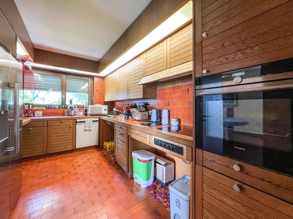 Küche mit warmen Holzmöbeln und Terrakottaboden