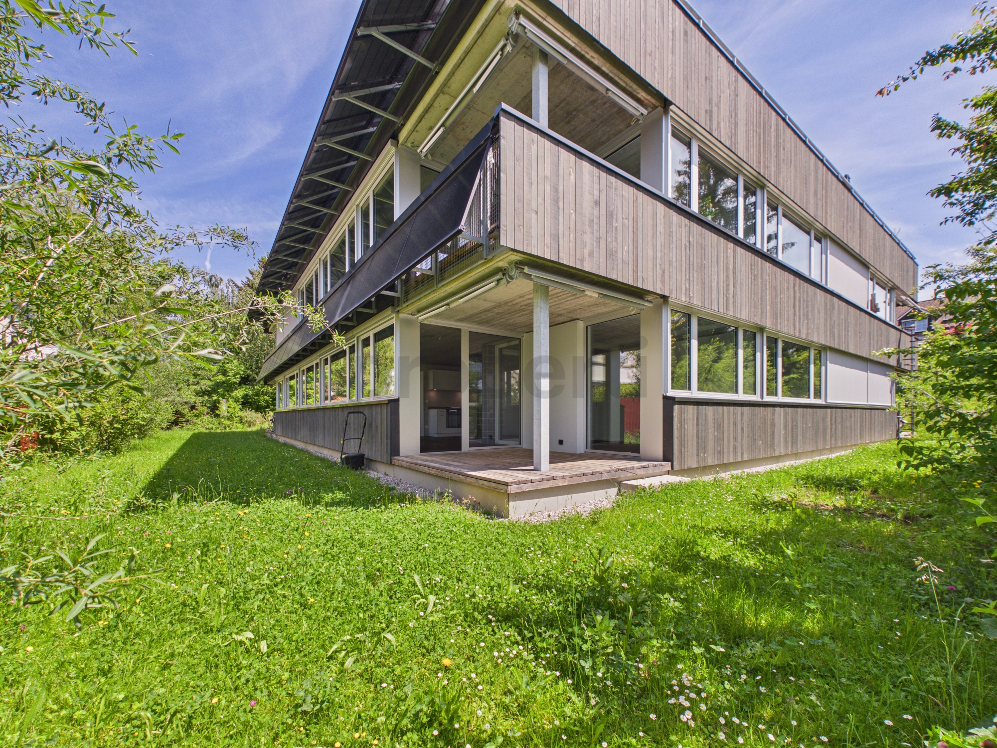 Modernes Wohnhaus mit Holzfassade und Garten