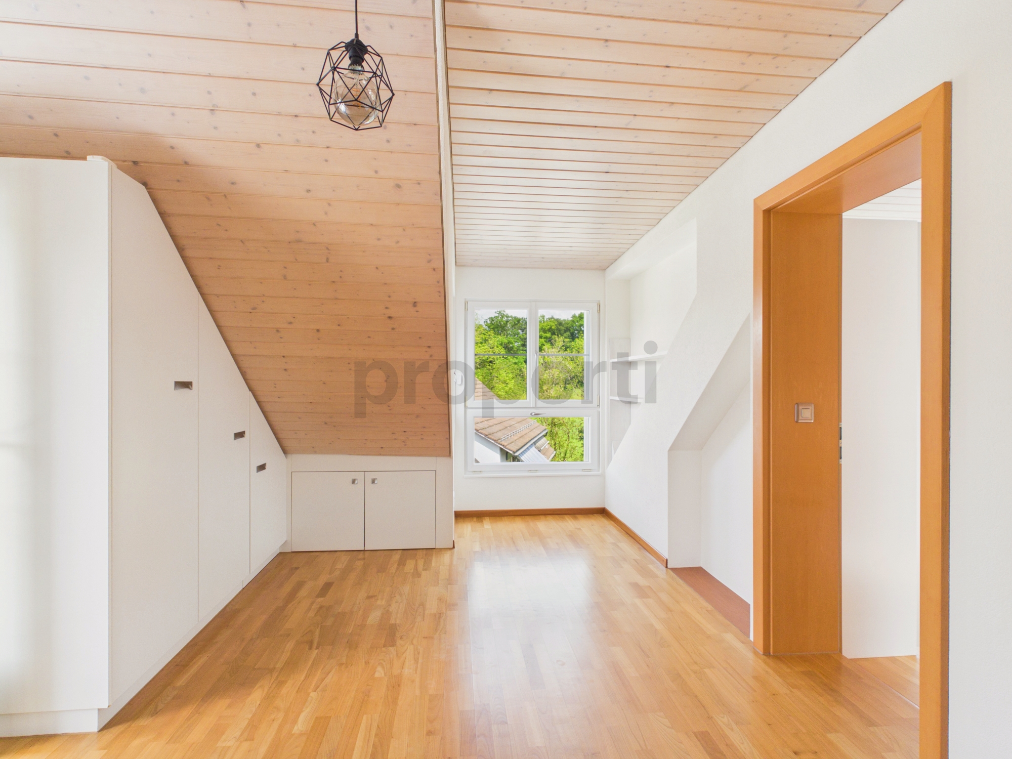 Heller Dachraum mit Holzdecke und Fenster