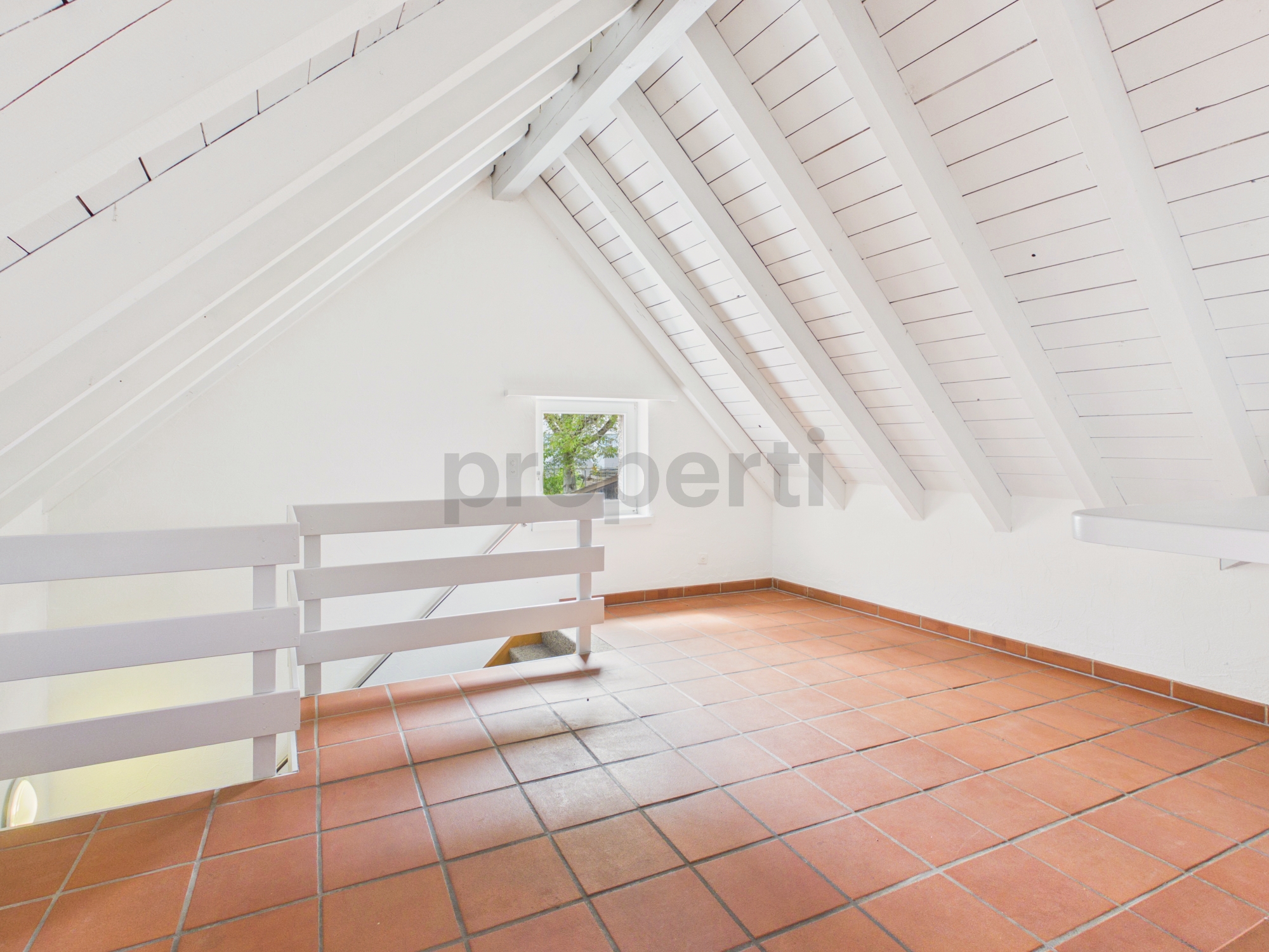 Heller Dachboden- bzw. Galeriebereich mit Terrakottafliesen