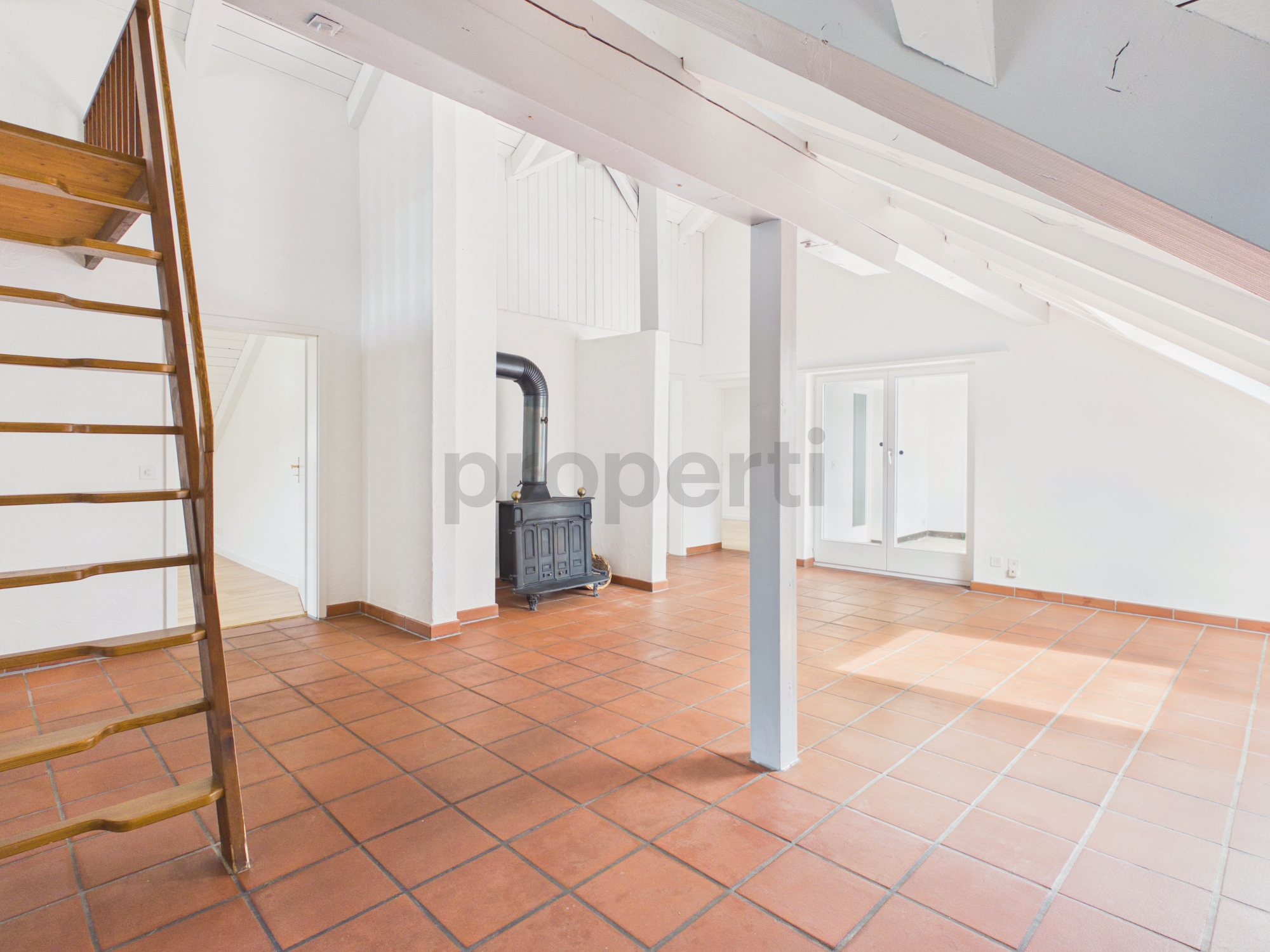 Heller Dachraum mit Kamin und Terrakottafliesen