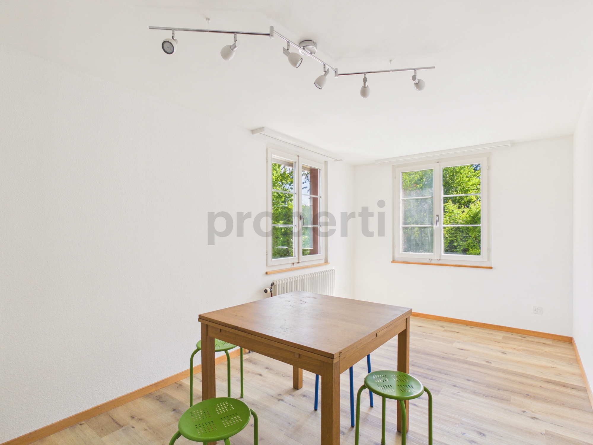 Heller leerer Raum mit Tisch und Hockern