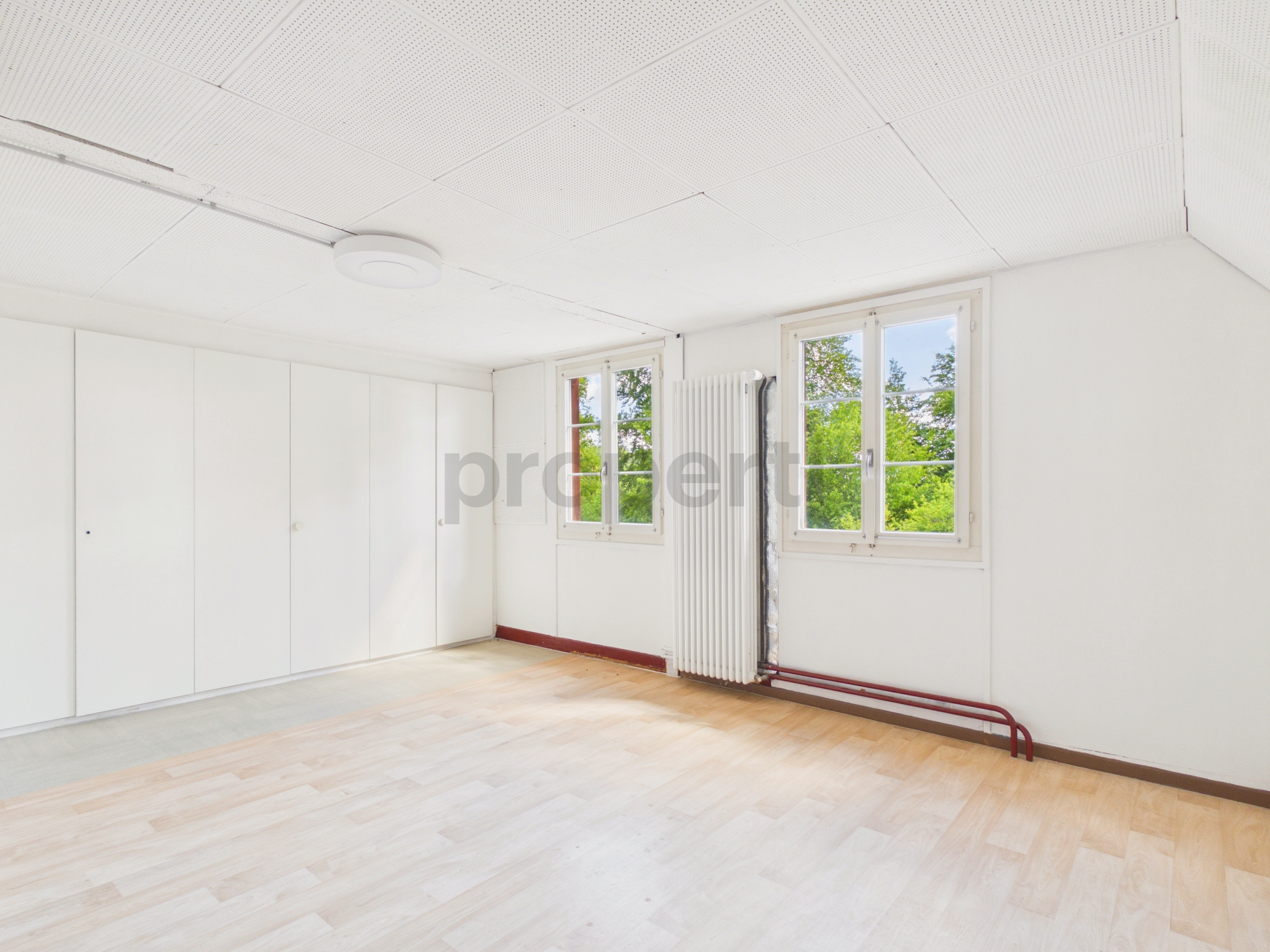 Helles leeres Zimmer mit Fenstern und Heizkörper