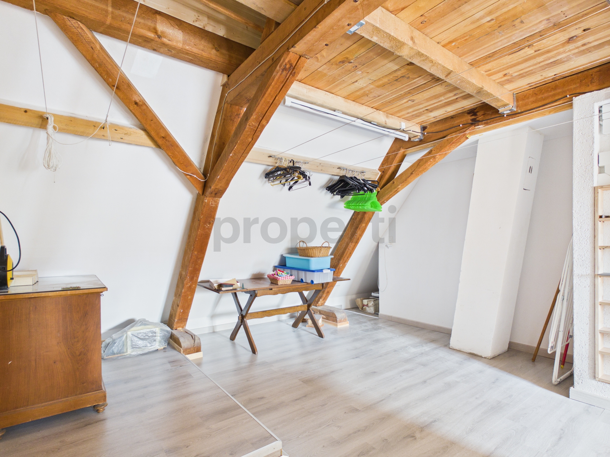 Dachgeschossraum mit sichtbaren Holzbalken