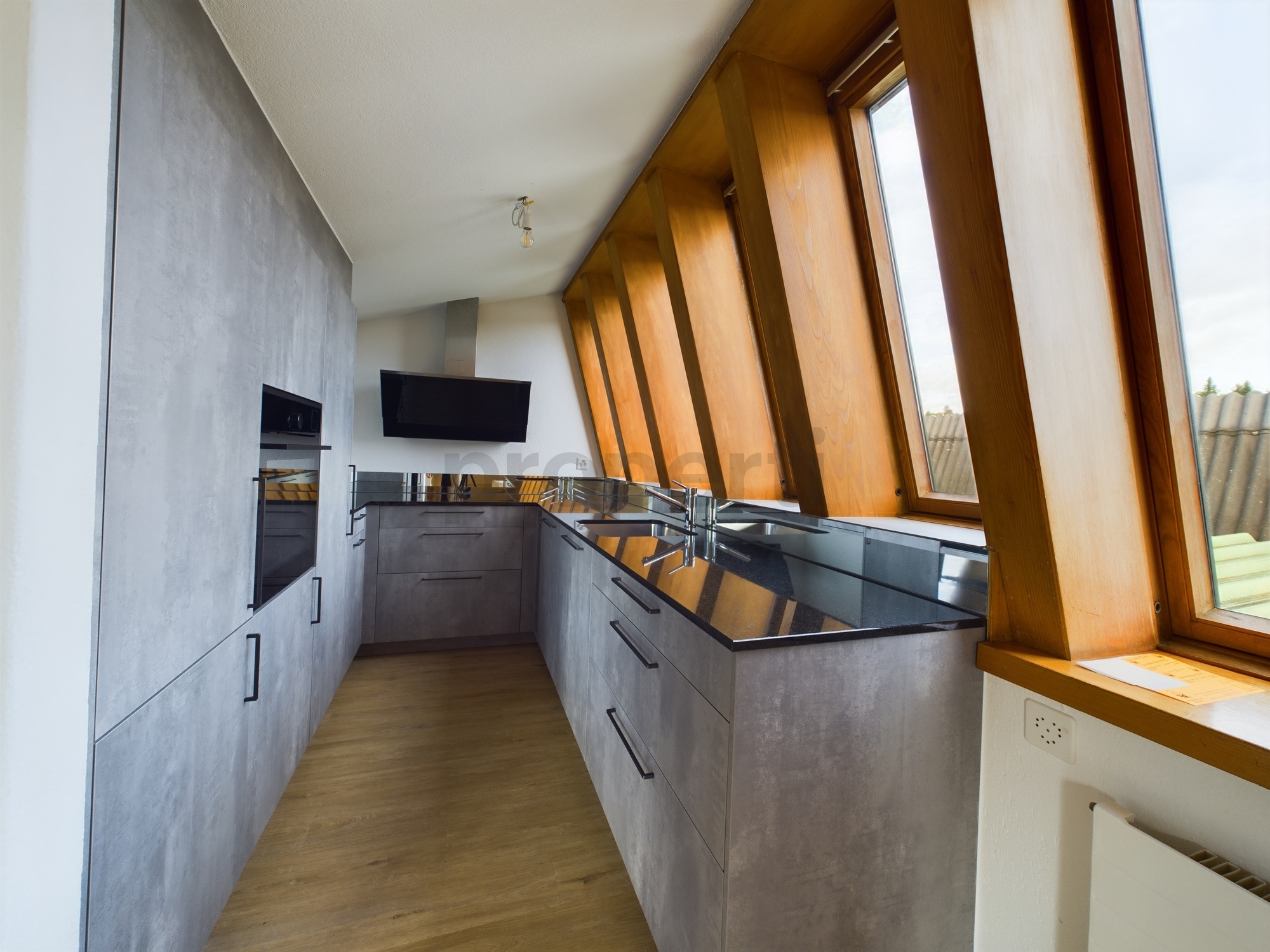 Moderne Dachgeschossküche mit schrägen Fenstern