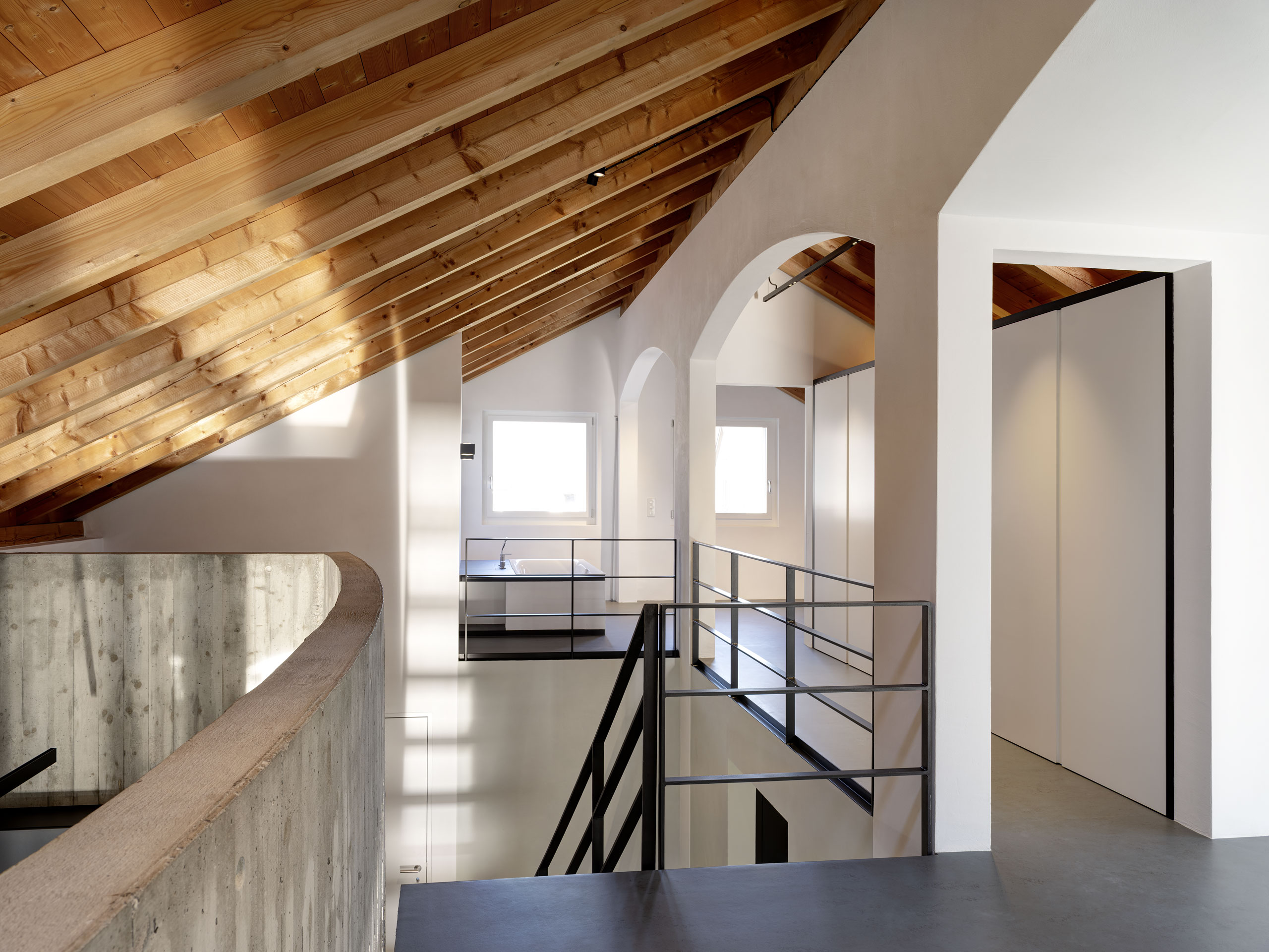 Modernes Treppenhaus mit Dachschrägen und Sichtbeton