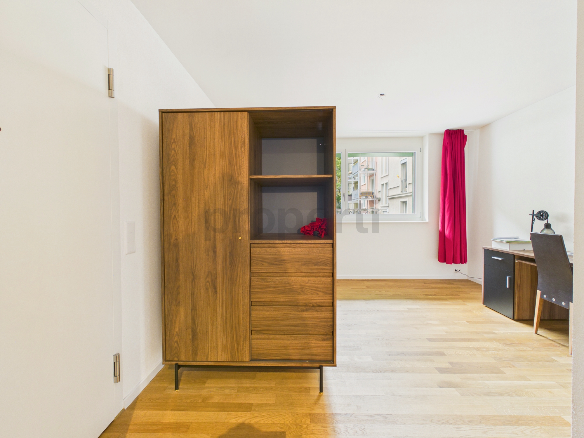 Helles Dachzimmer mit Schrank und Schreibtisch