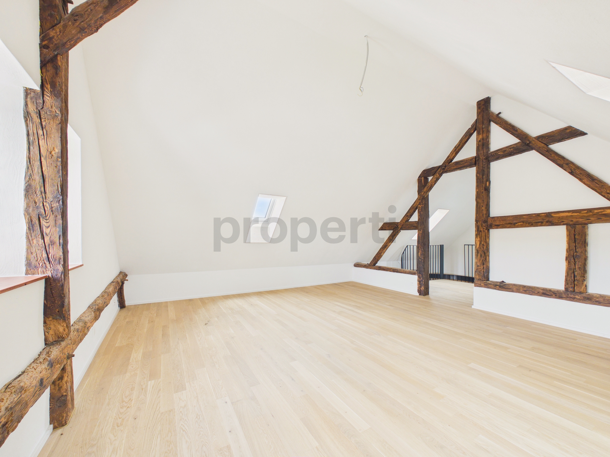 Dachgeschossraum mit sichtbaren Holzbalken