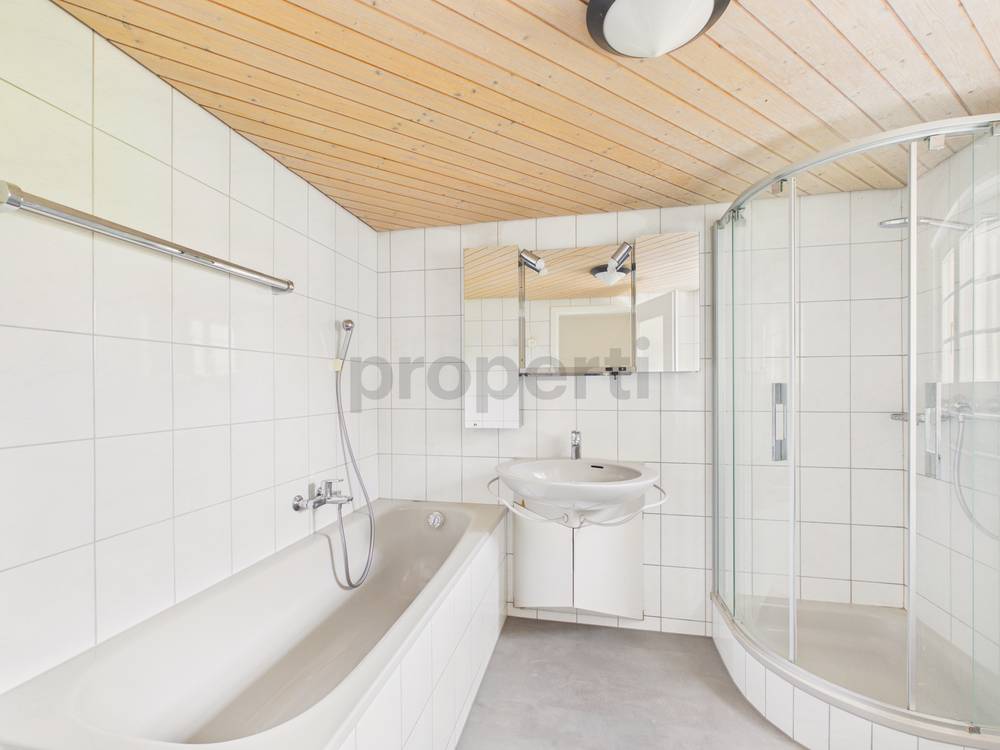 Helles Badezimmer mit Badewanne und Duschkabine