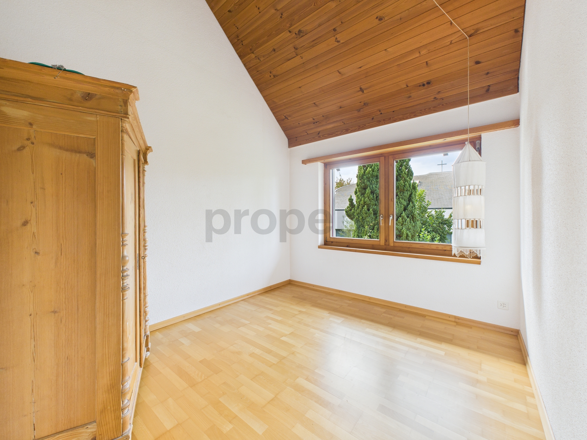 Helles Zimmer mit Holzdecke und Dachfenster