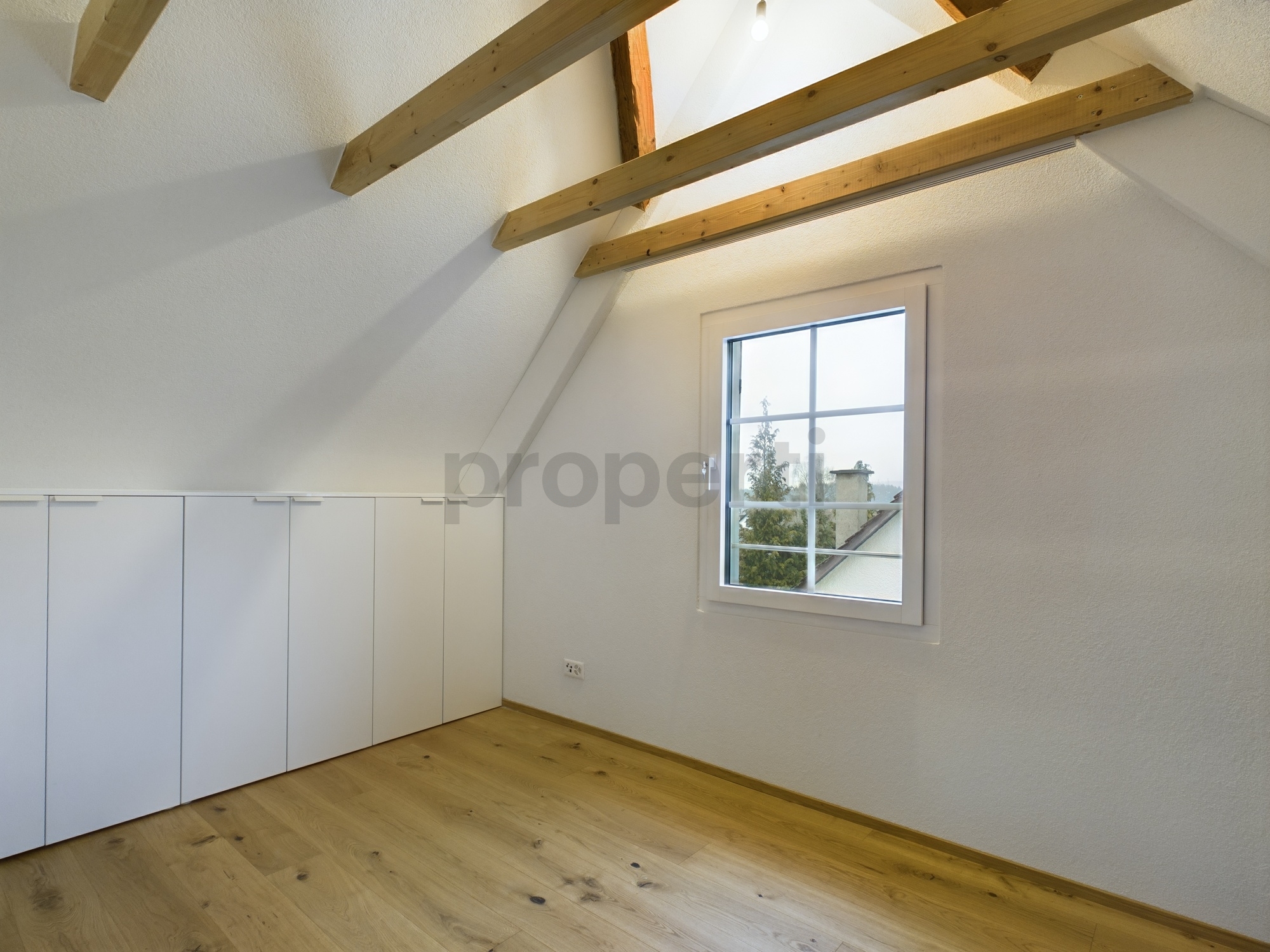 Dachzimmer mit Fenster und Einbauschrank