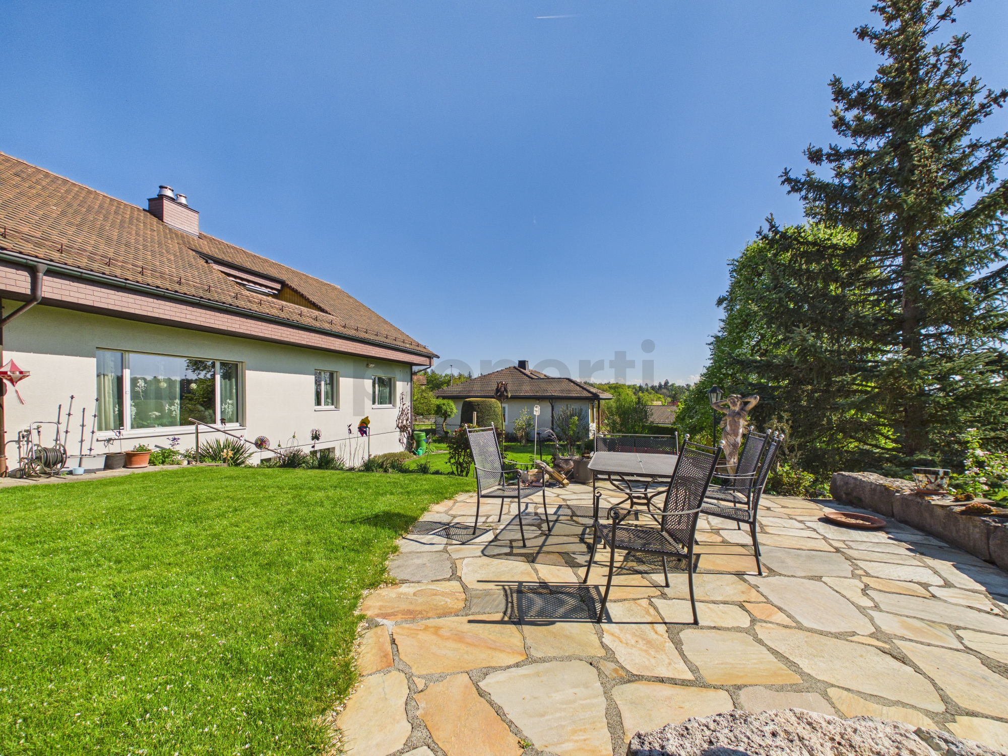 Gepflegter Garten mit Terrasse und Hausansicht