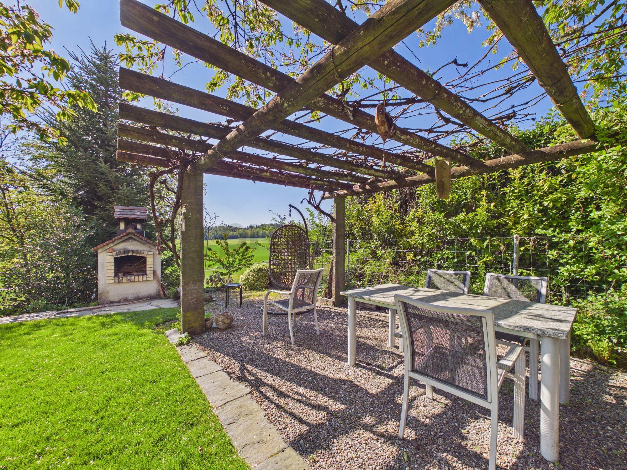 Überdachte Gartenlounge mit Pergola und Sitzbereich