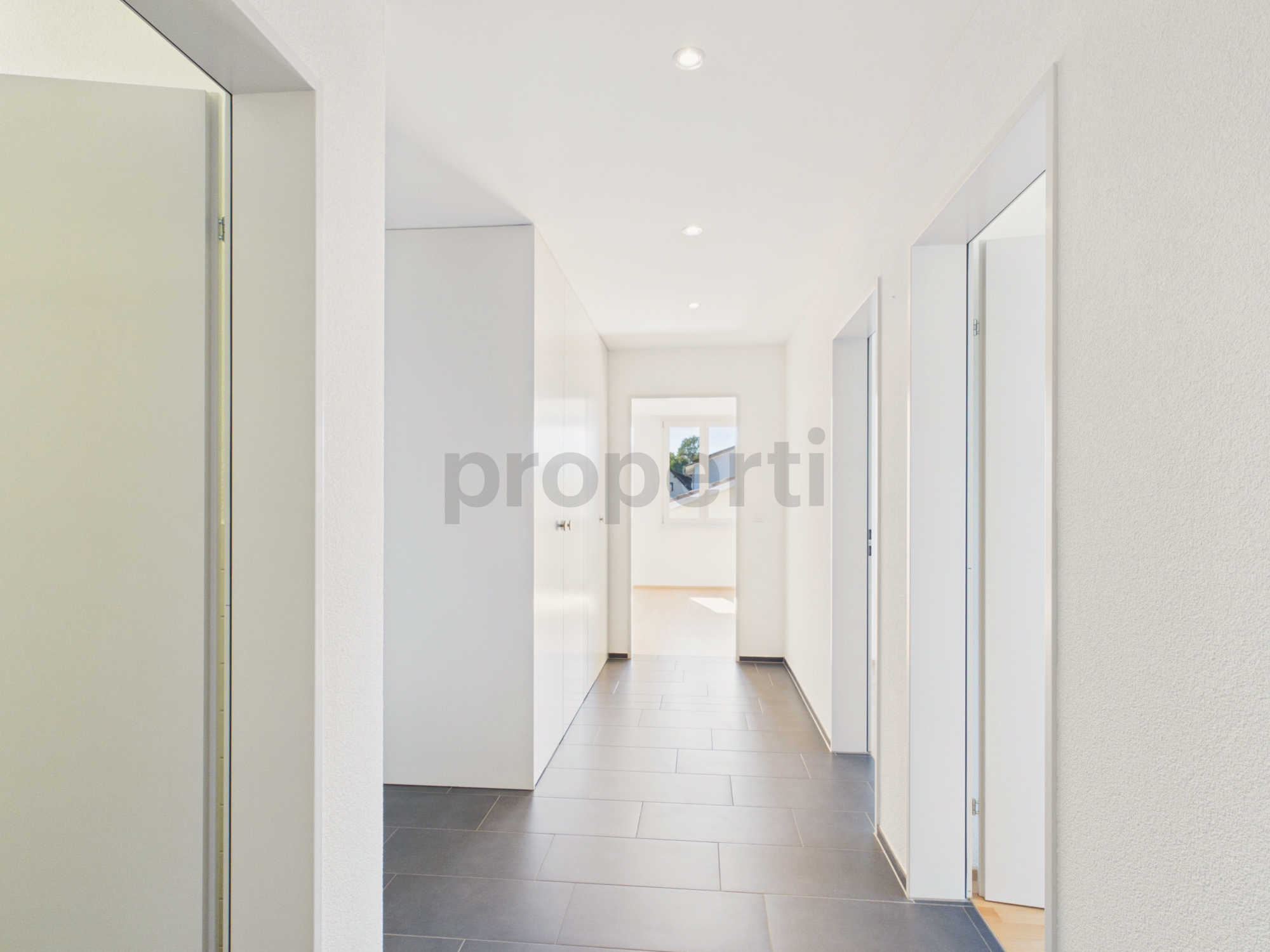 Heller, moderner Flur mit Blick in einen weiteren Raum