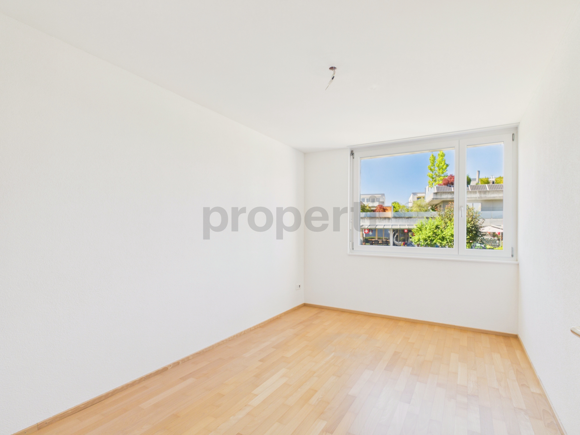 Heller leerer Raum mit Fenster und Holzboden