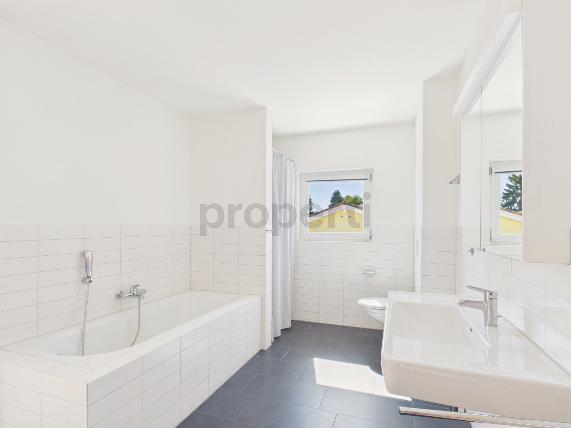 Helles Badezimmer mit Badewanne und Waschtisch