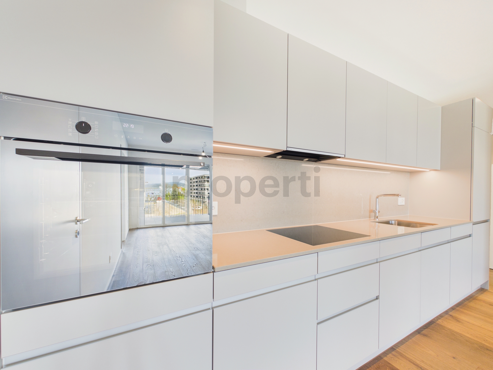 Moderne weiße Küche mit Blick in den Wohnbereich
