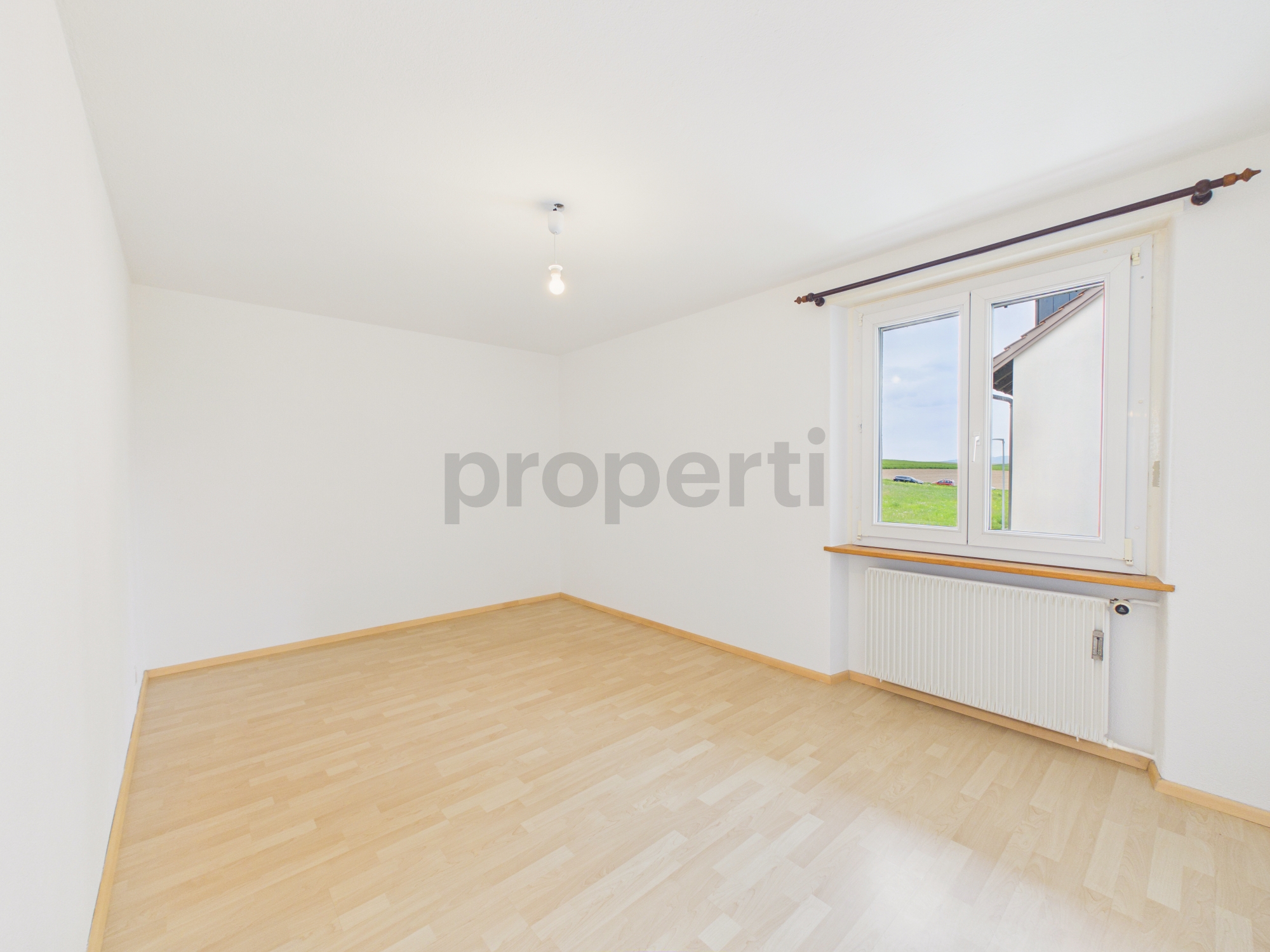 Leerer heller Raum mit Fenster und Heizkörper