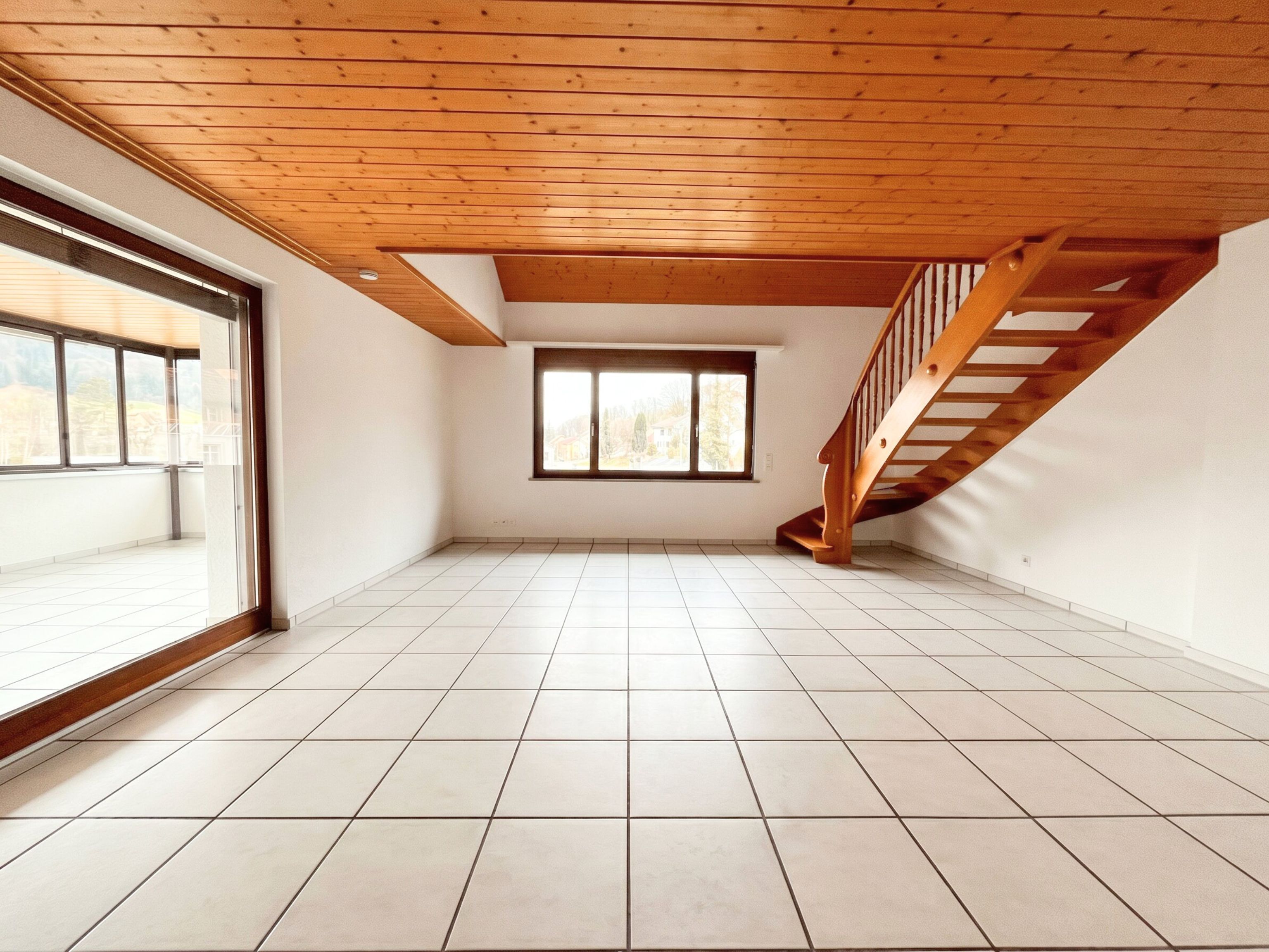 Heller Wohnraum mit Holzdecke und Treppe