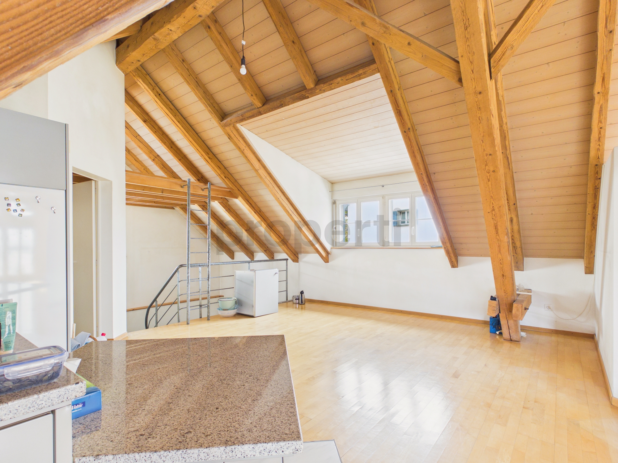Ausgebauter Dachgeschossraum mit sichtbaren Holzbalken
