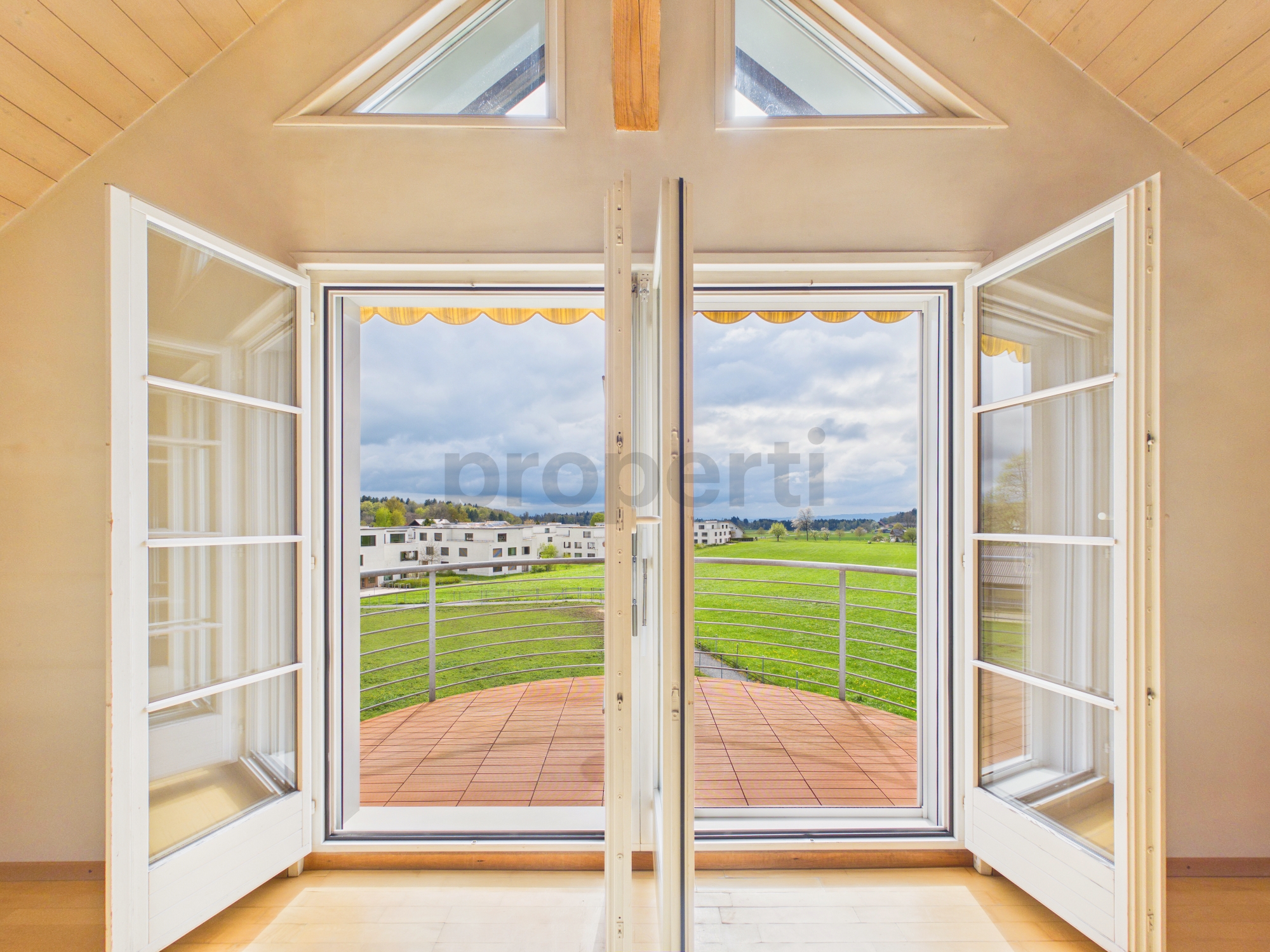 Heller Dachgeschossraum mit Balkonblick
