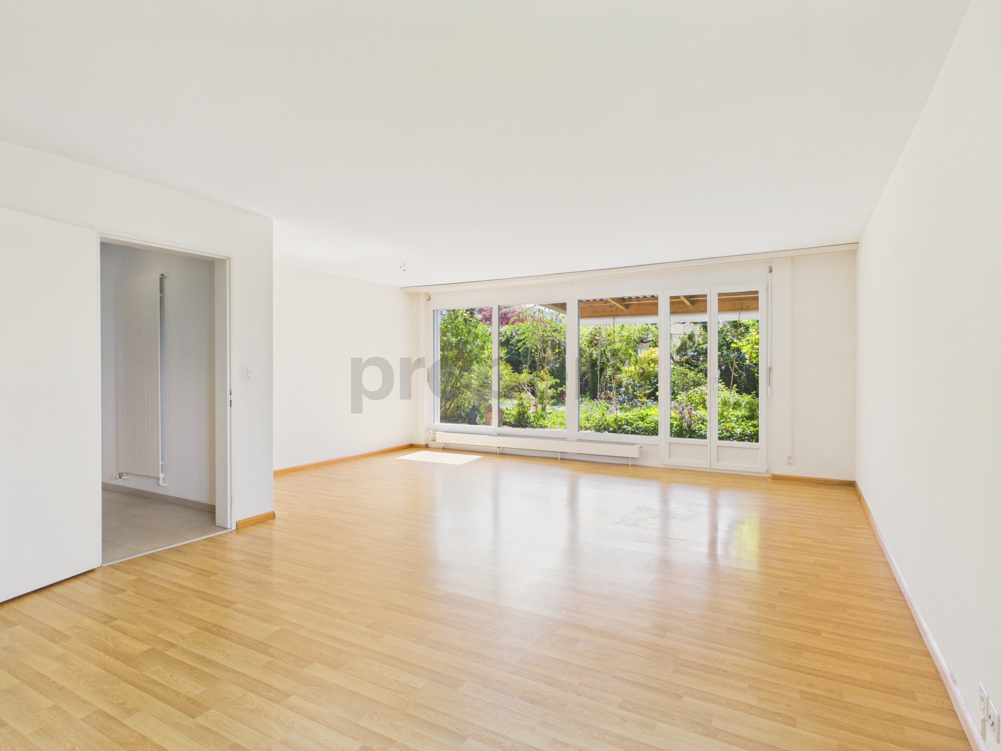 Heller leerer Wohnraum mit großer Fensterfront