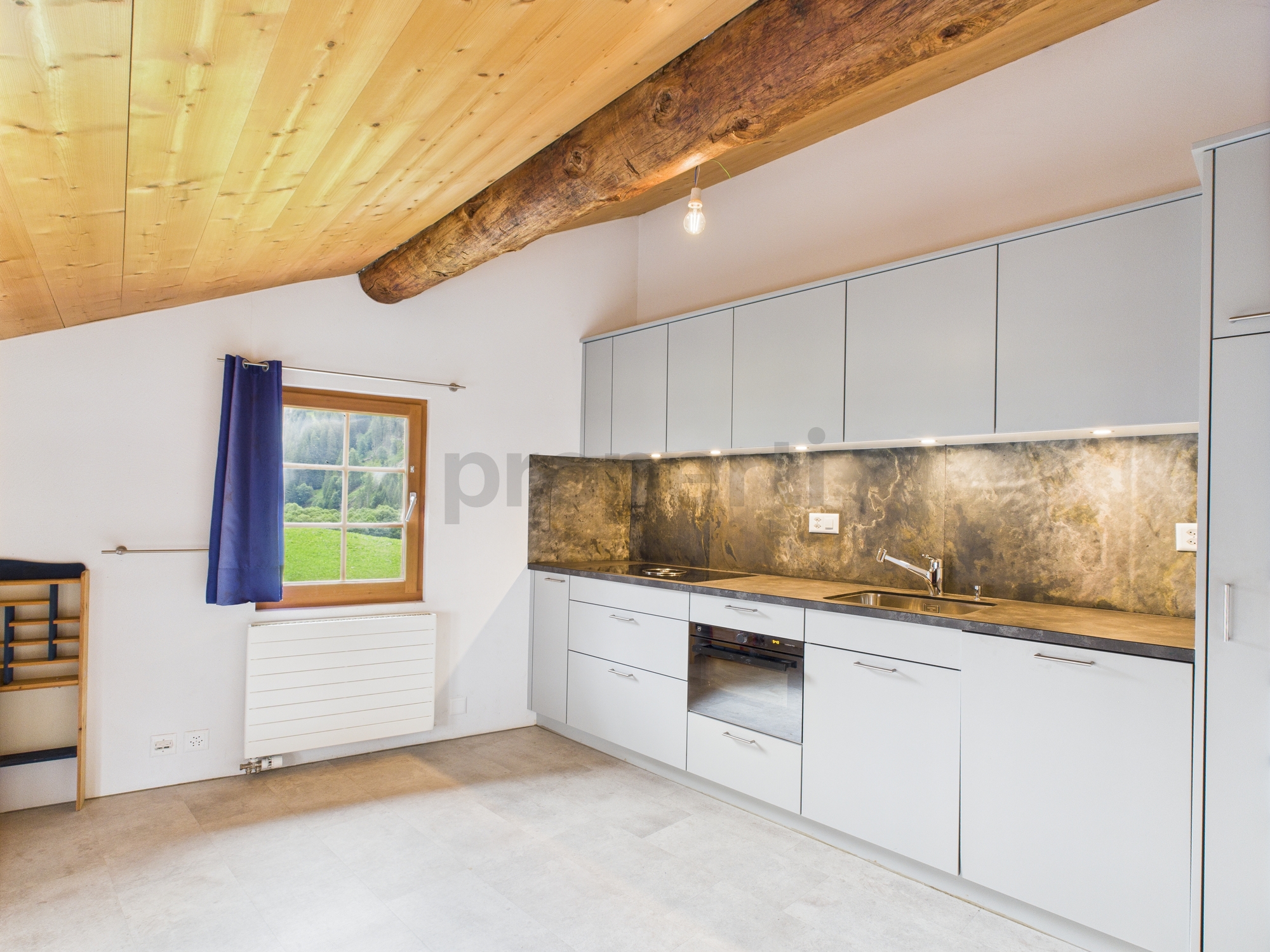 Moderne Küche mit Holzbalken und Blick ins Grüne