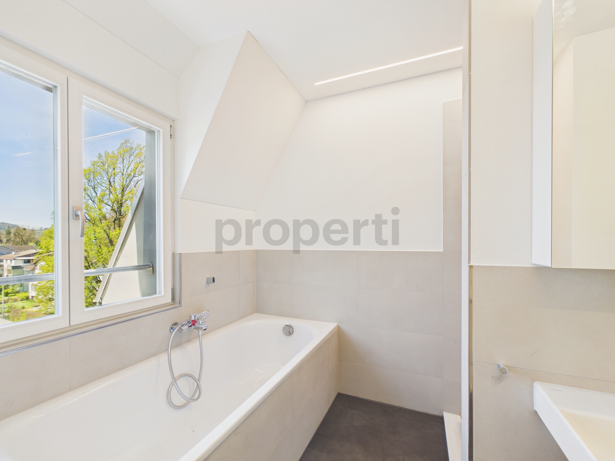 Modernes Badezimmer mit Badewanne und Fensterblick