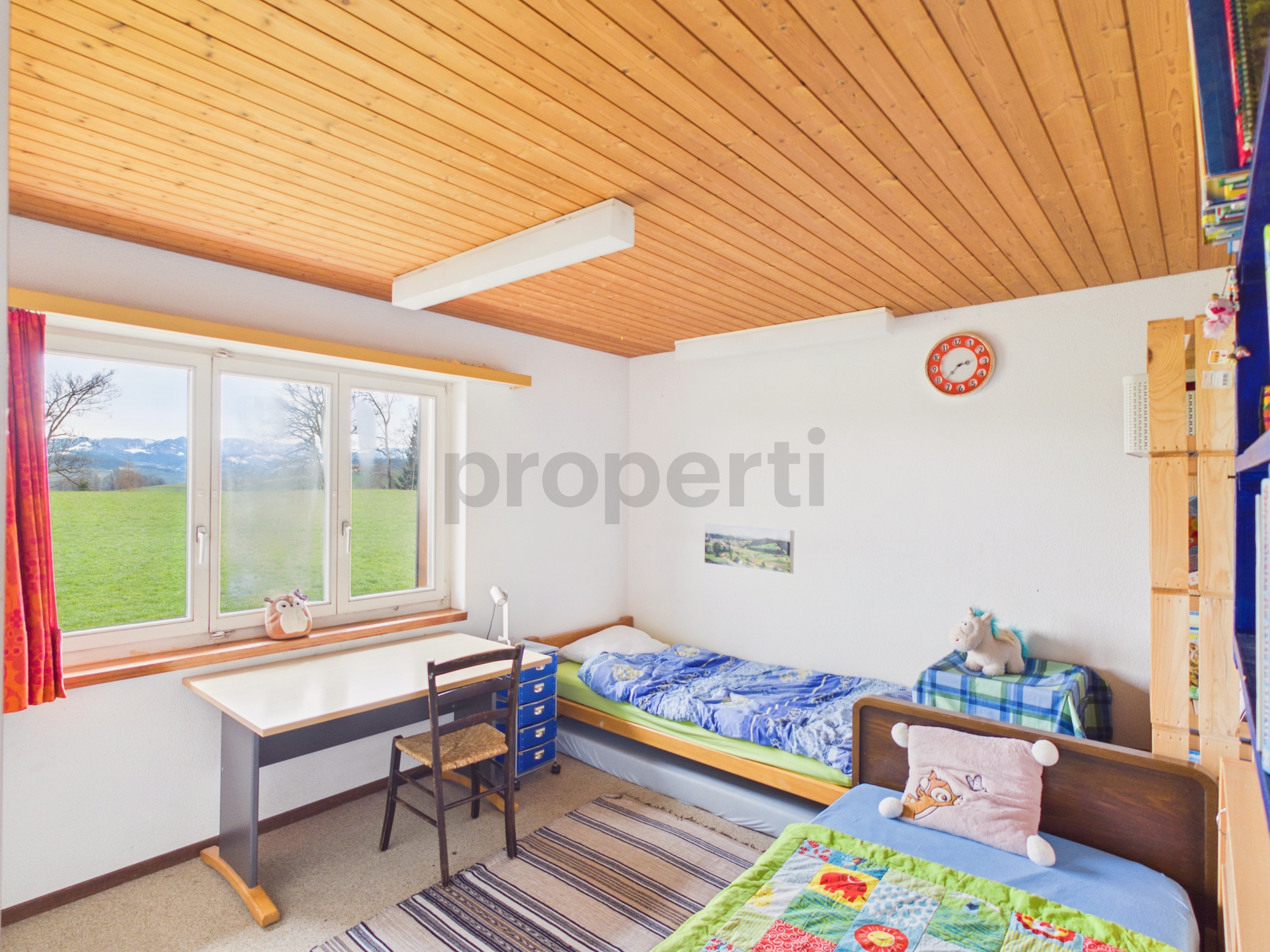 Kinderzimmer mit zwei Betten und Holzbalkendecke