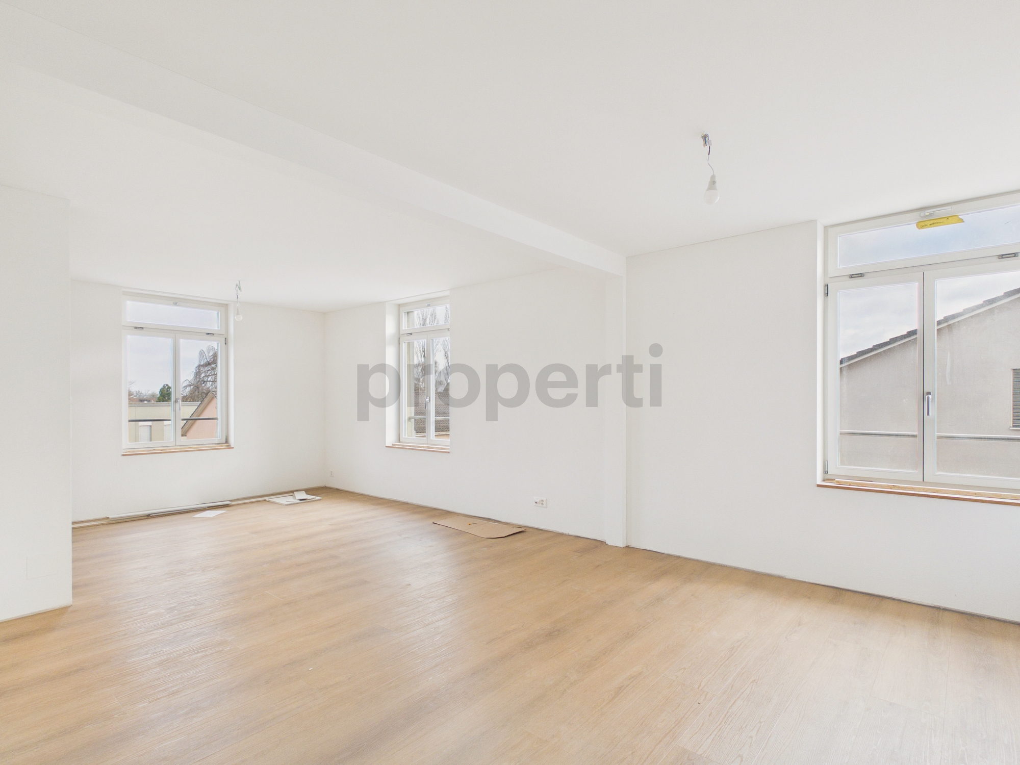 Leeres, helles Zimmer mit großen Fenstern
