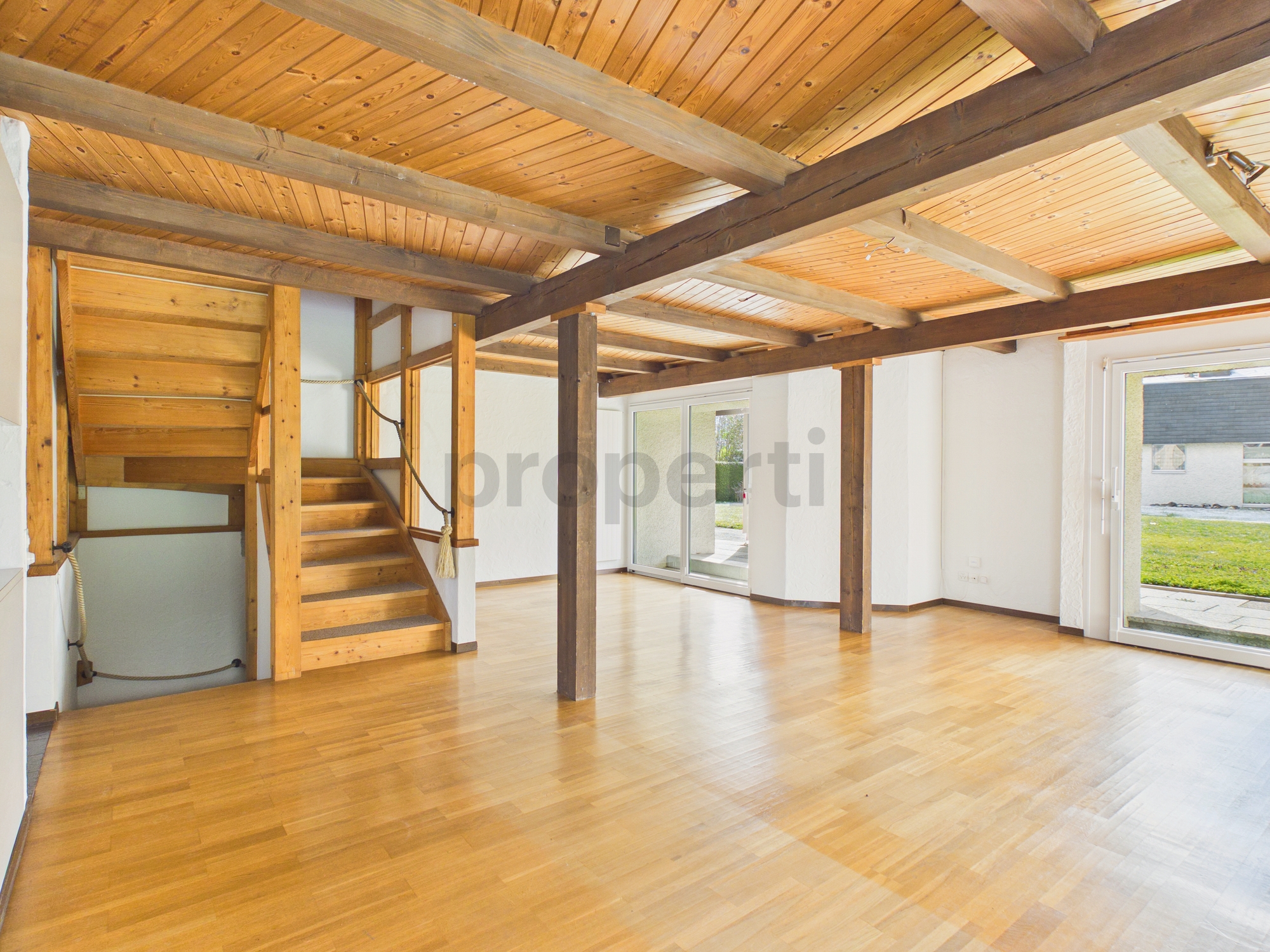 Heller Wohnraum mit Holzdecke und sichtbaren Balken