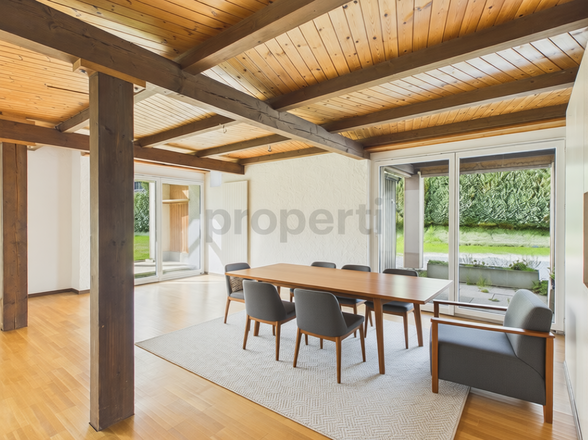 Heller Essbereich mit Holzbalken und Gartenblick
